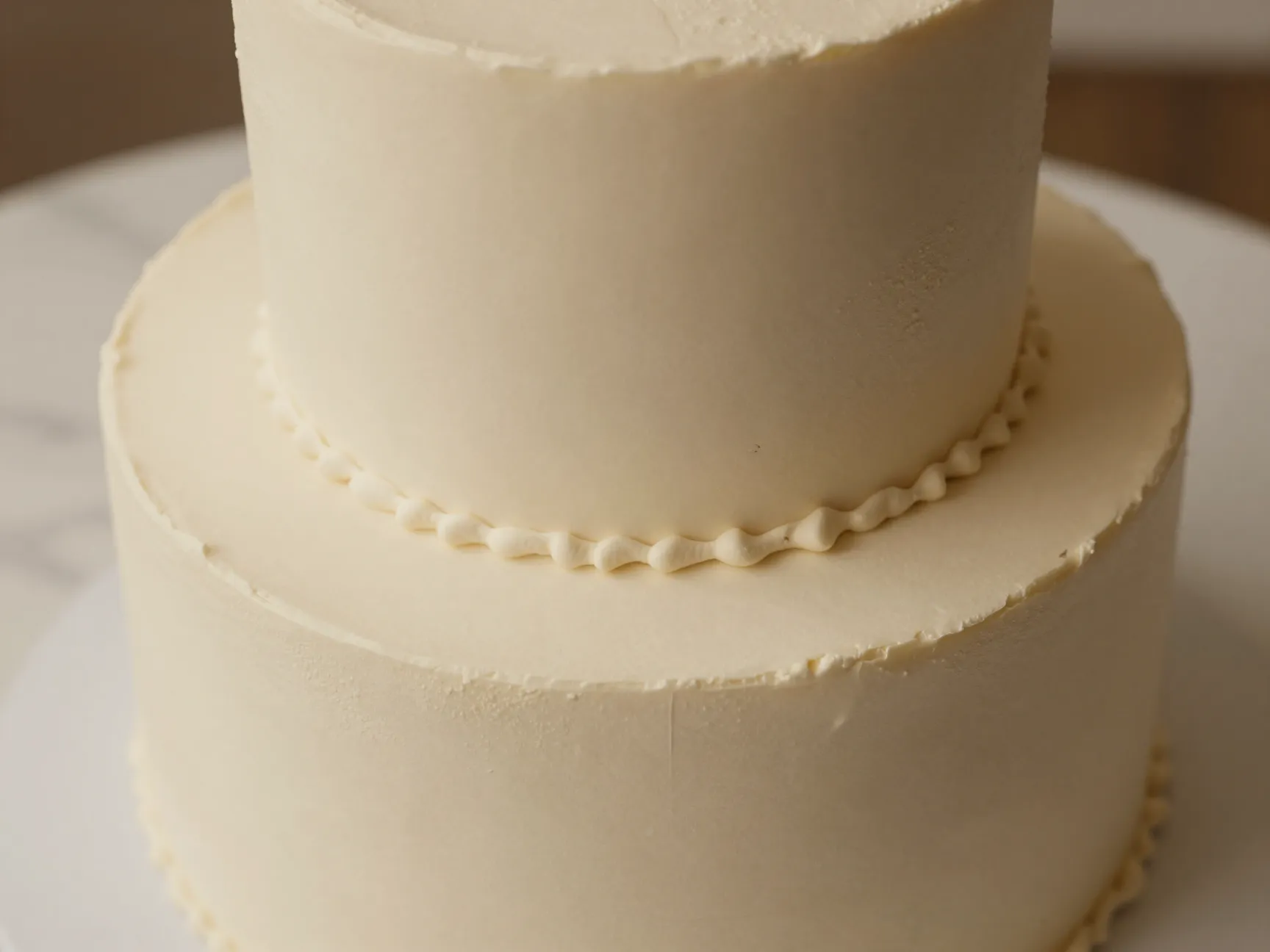 Monochrome minimalist ivory cake with varied textured surfaces