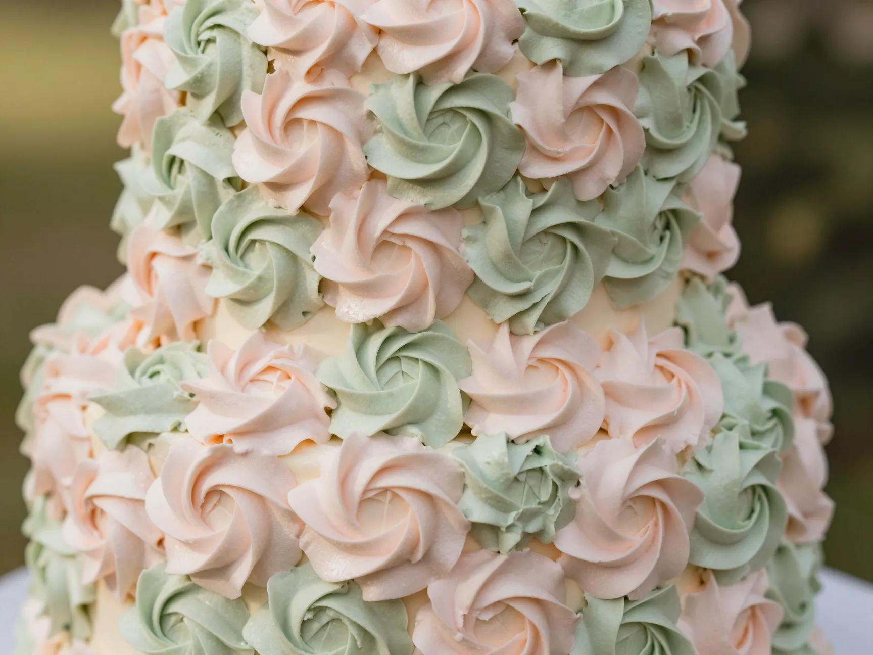 Piped buttercream rosette cake in blush and sage green tones