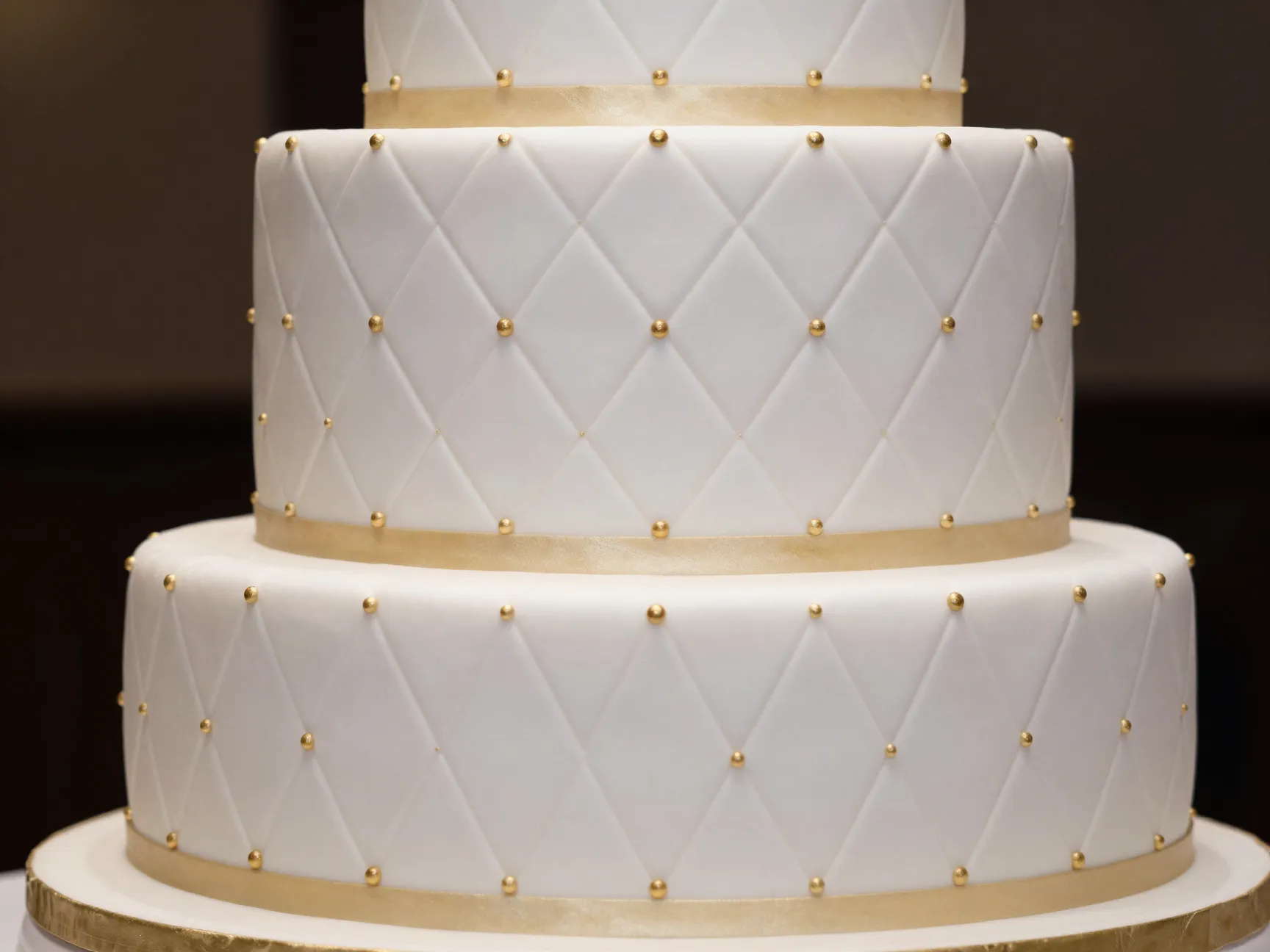 Quilted fondant wedding cake with diamond pattern and gold accents