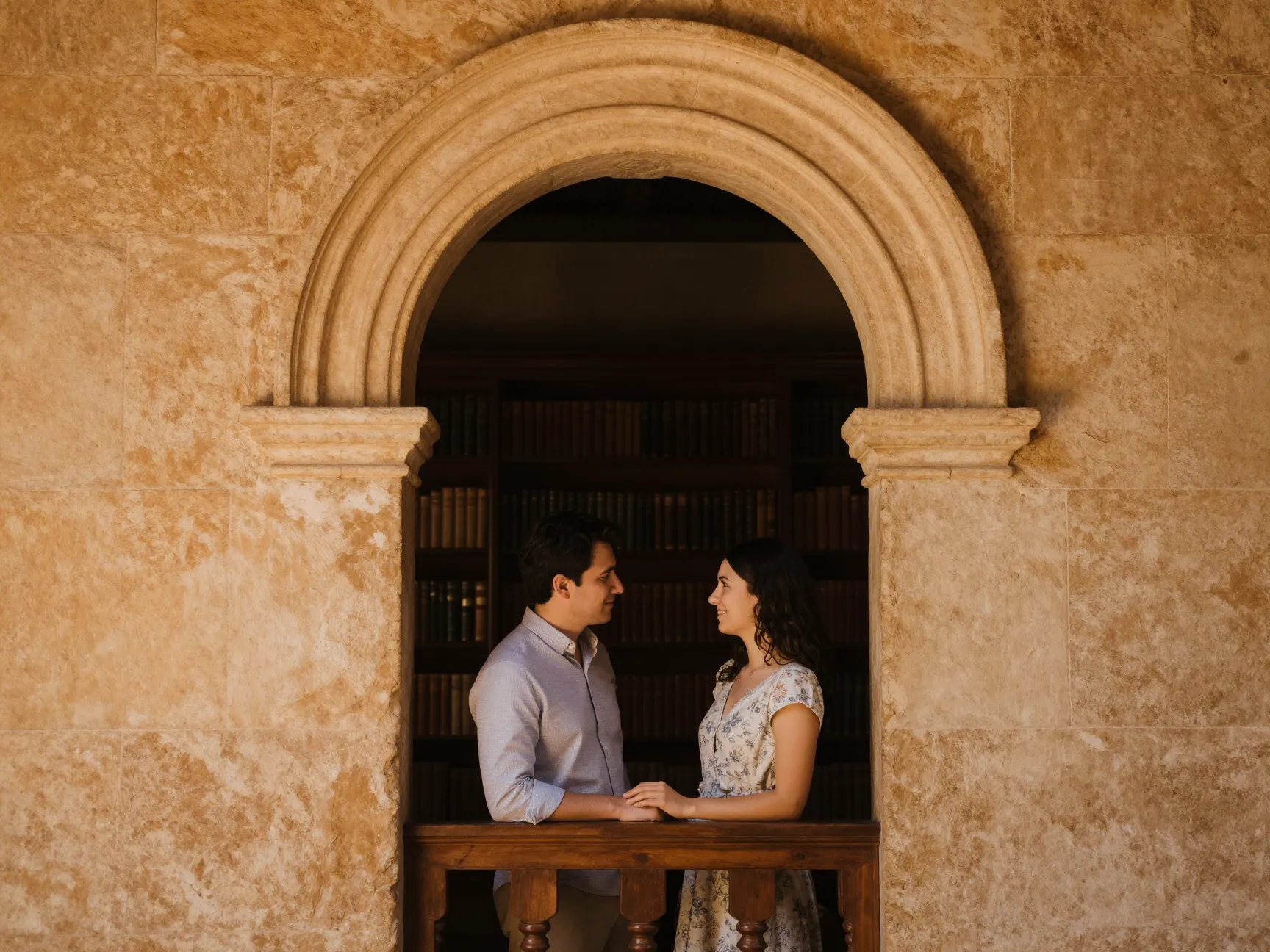 Couple framed in spanish renaissance library arched stone doorway