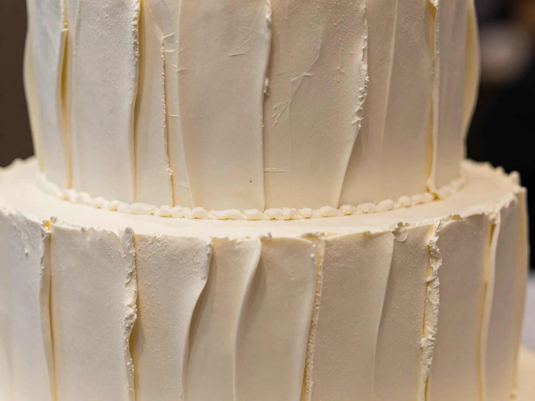 Textured buttercream wedding cake with pleated panels