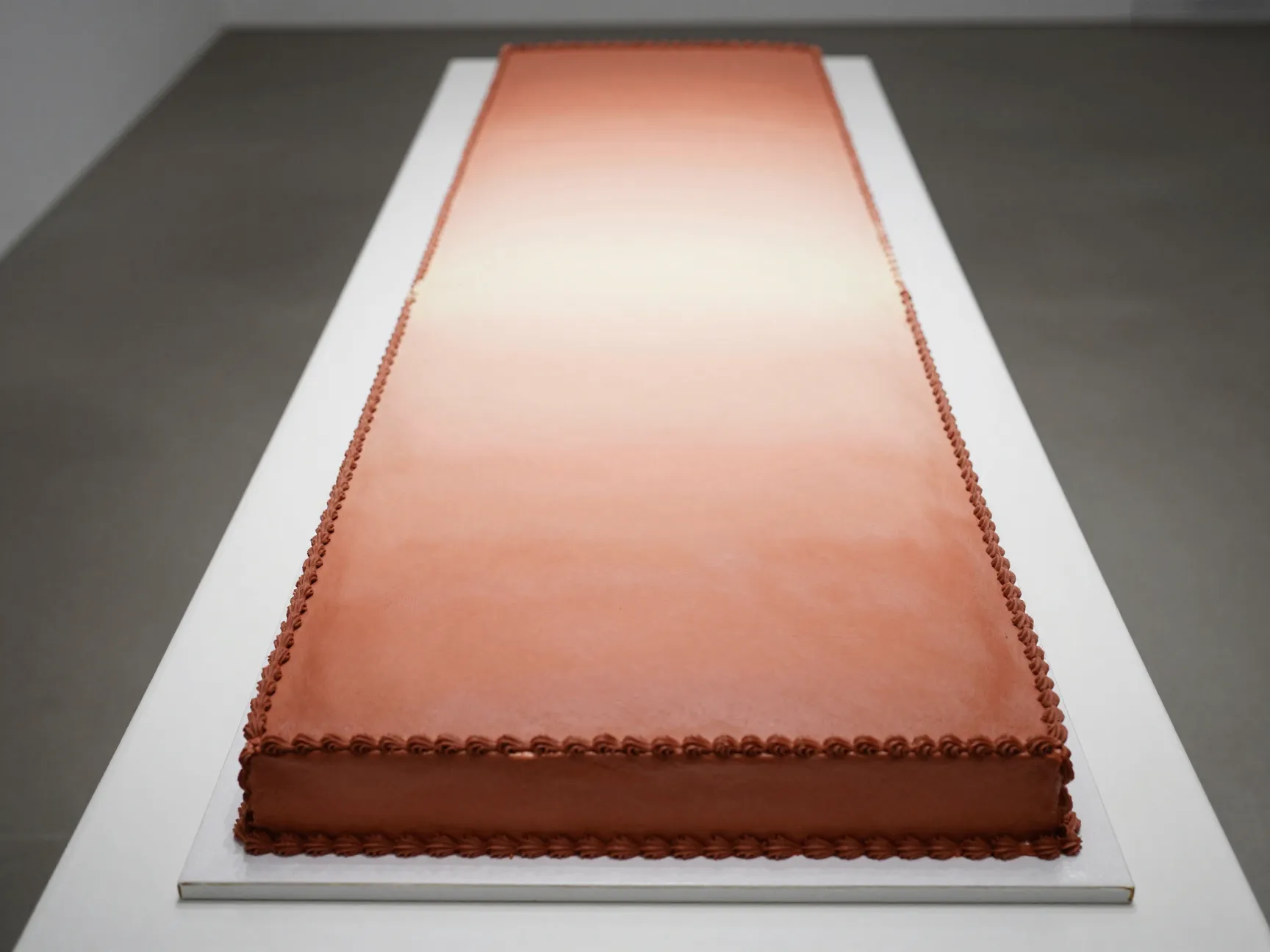 Long rectangular table spanning sheet cake with gradient color wash