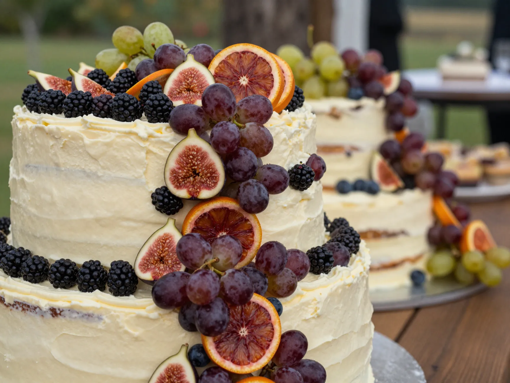Wedding cake adorned with fresh blackberries figs blood oranges grapes