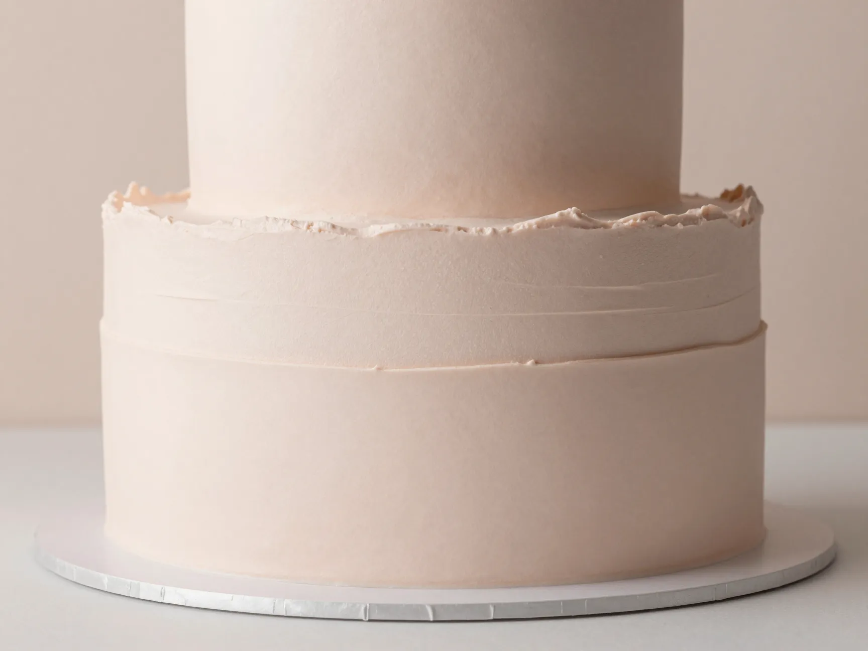 Monochrome minimalist cake with texture variations in soft blush color