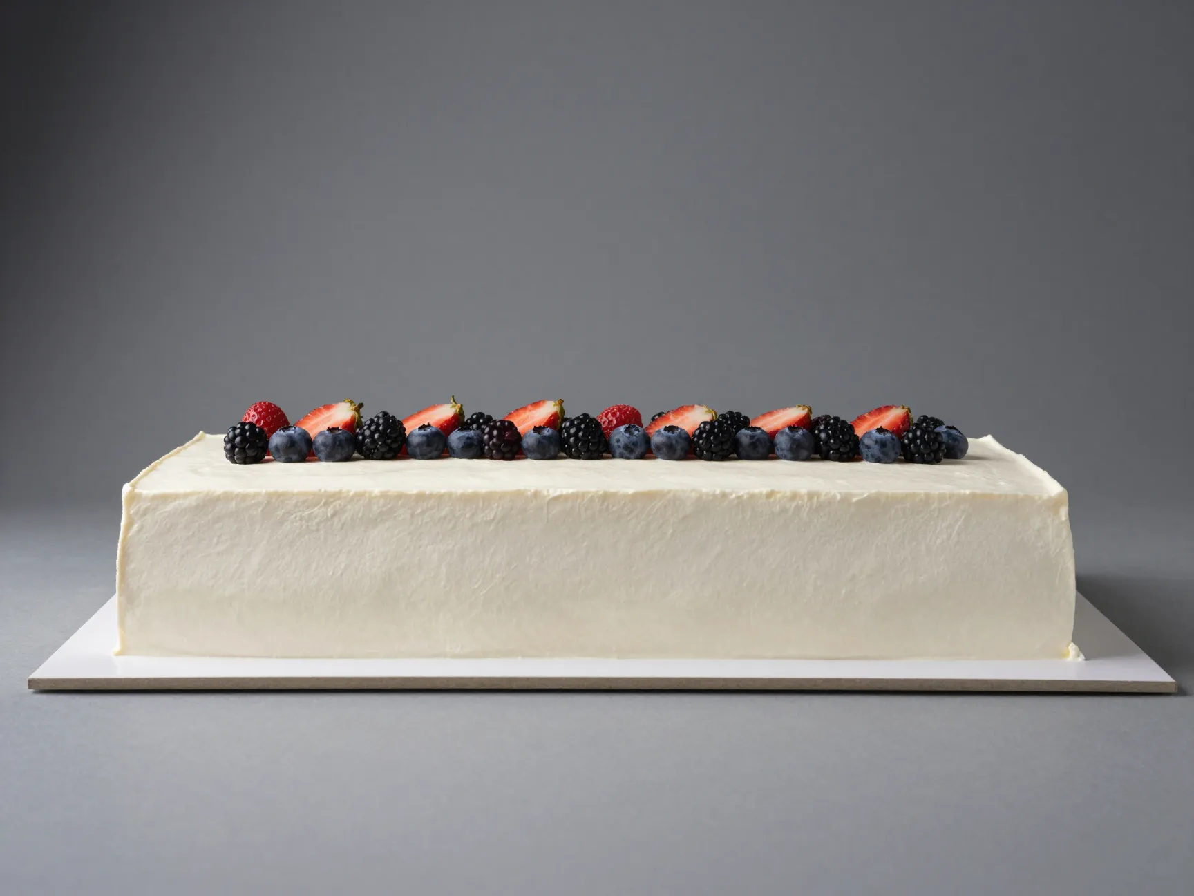 Rectangular modern cake with clean architectural lines and fresh fruit