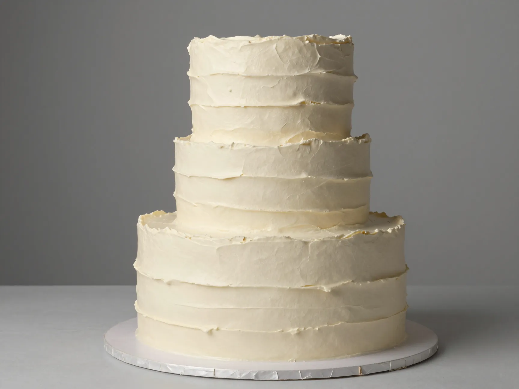 Short wide two tier cake with different textured buttercream finishes