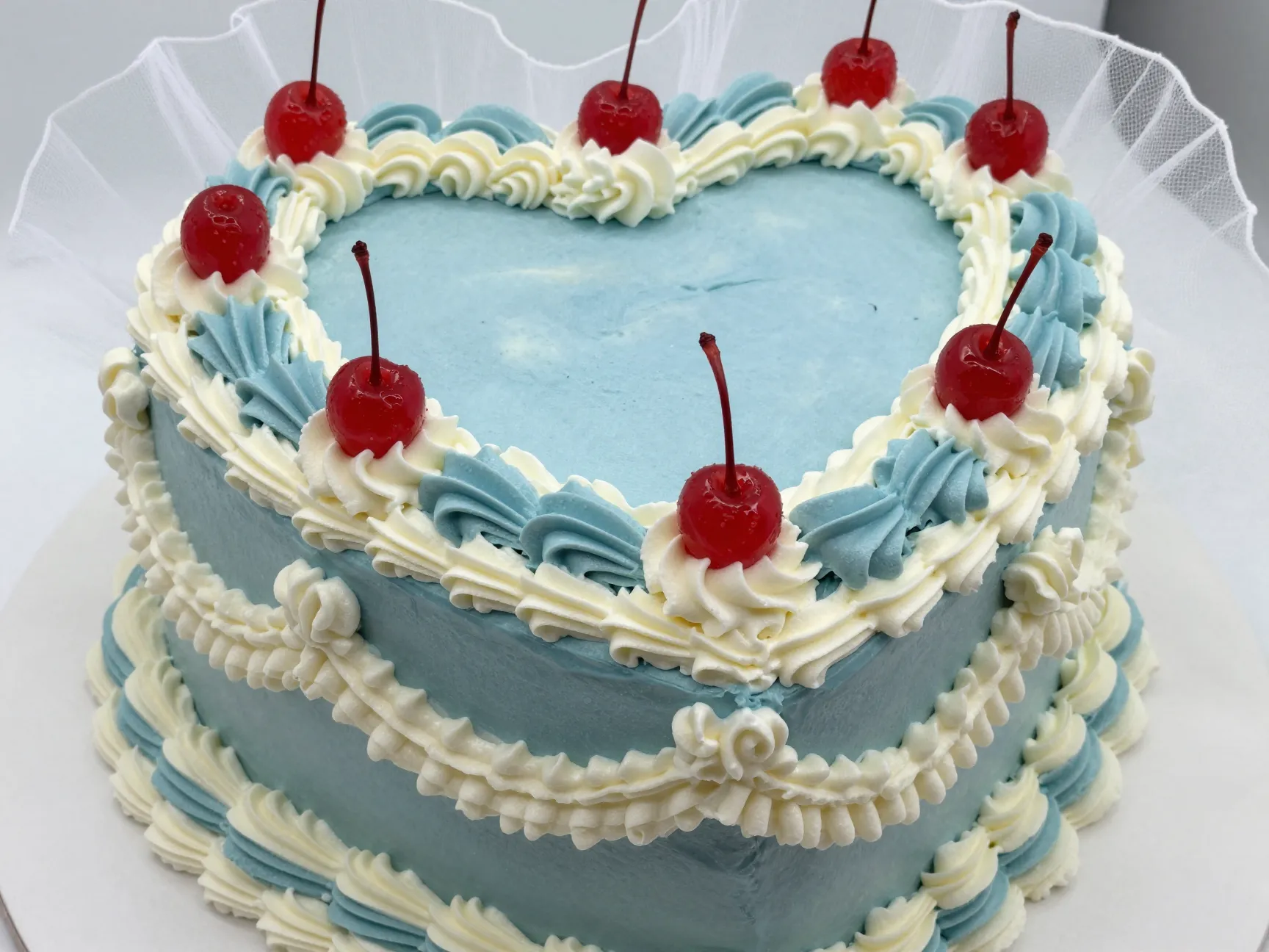 Lambeth style piped heart cake with dusty blue frosting and tulle