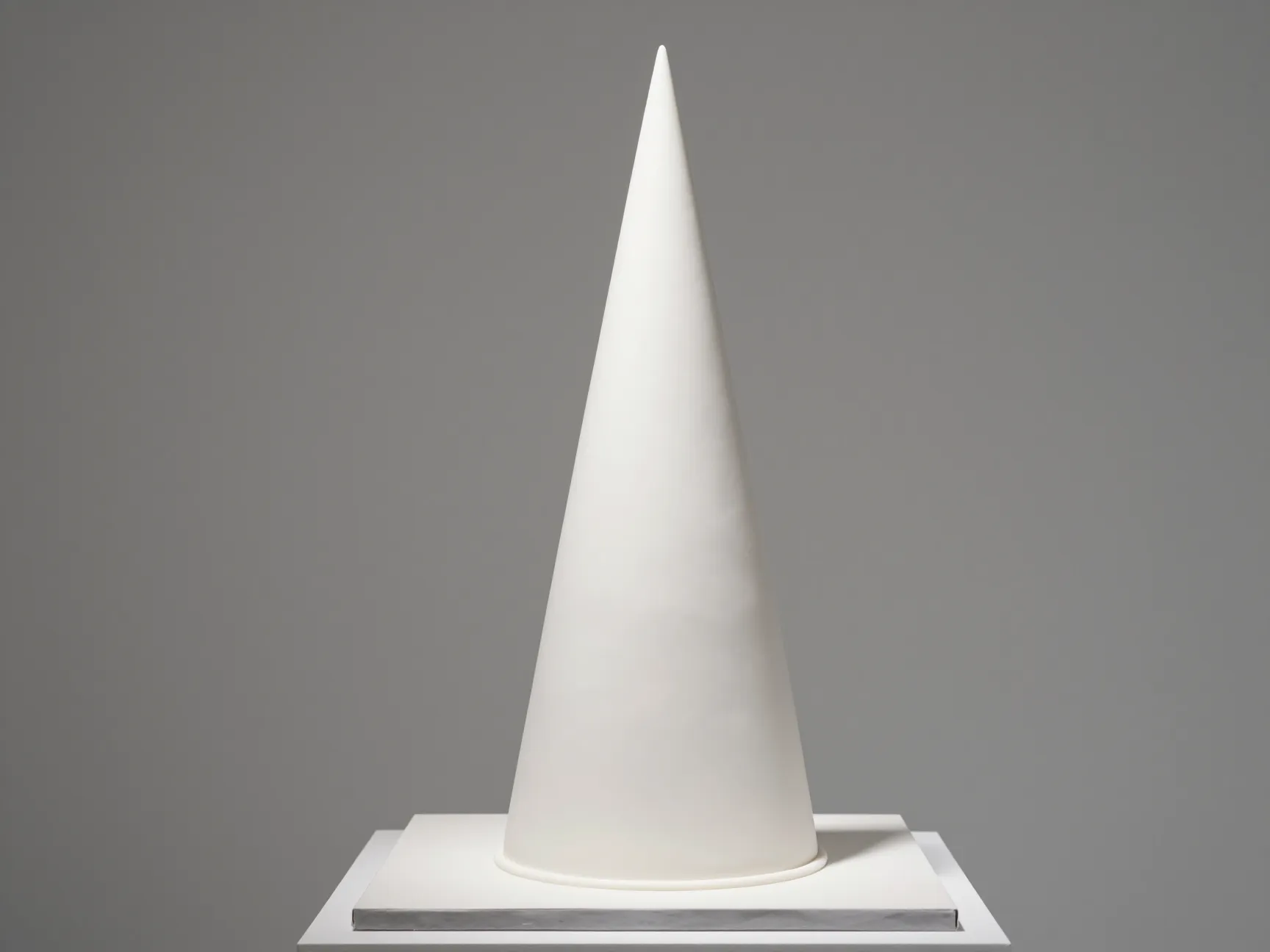 Tall smooth white fondant cone shaped architectural cake
