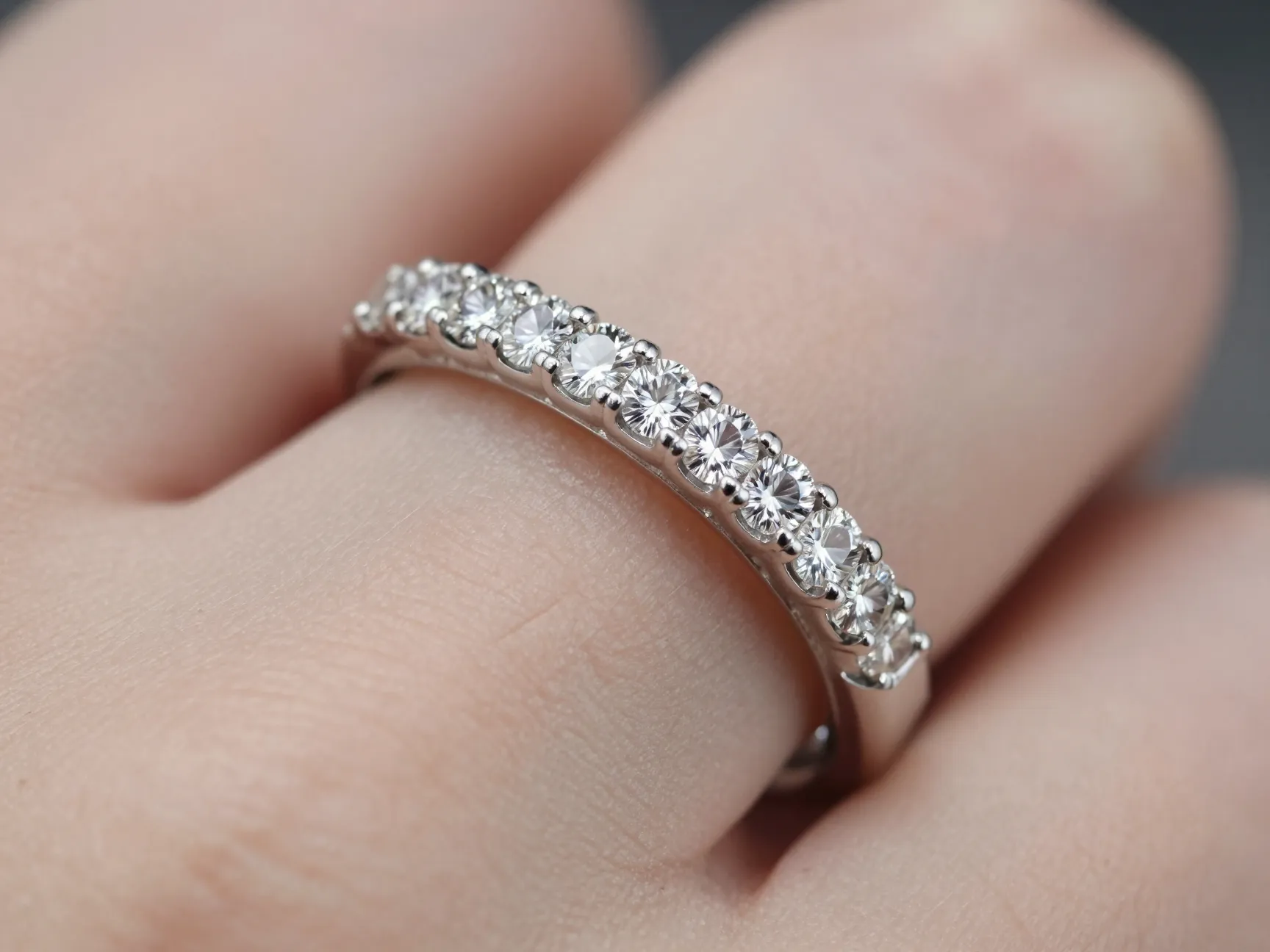 Step cut emerald eternity band in platinum channel setting