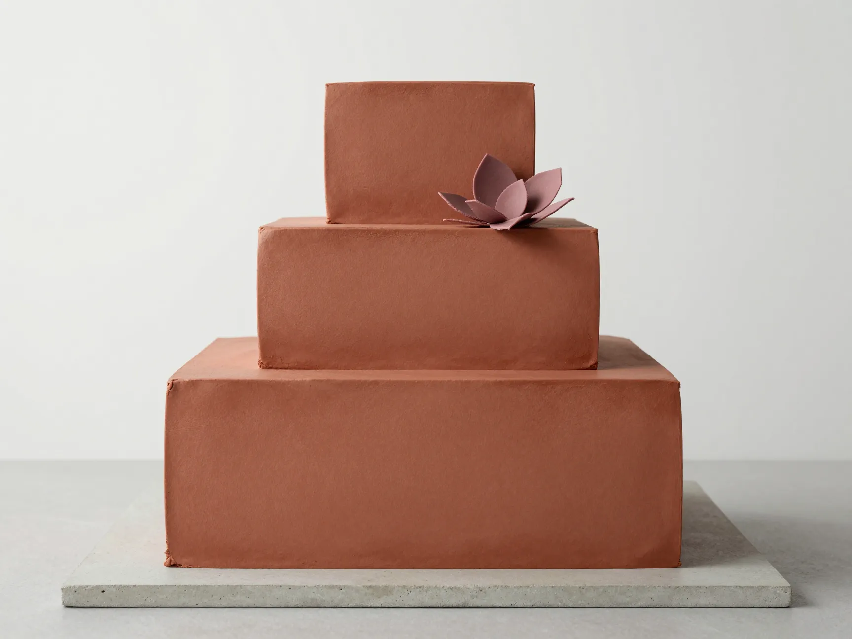 Modern minimalist square tiered cake in matte terracotta tone