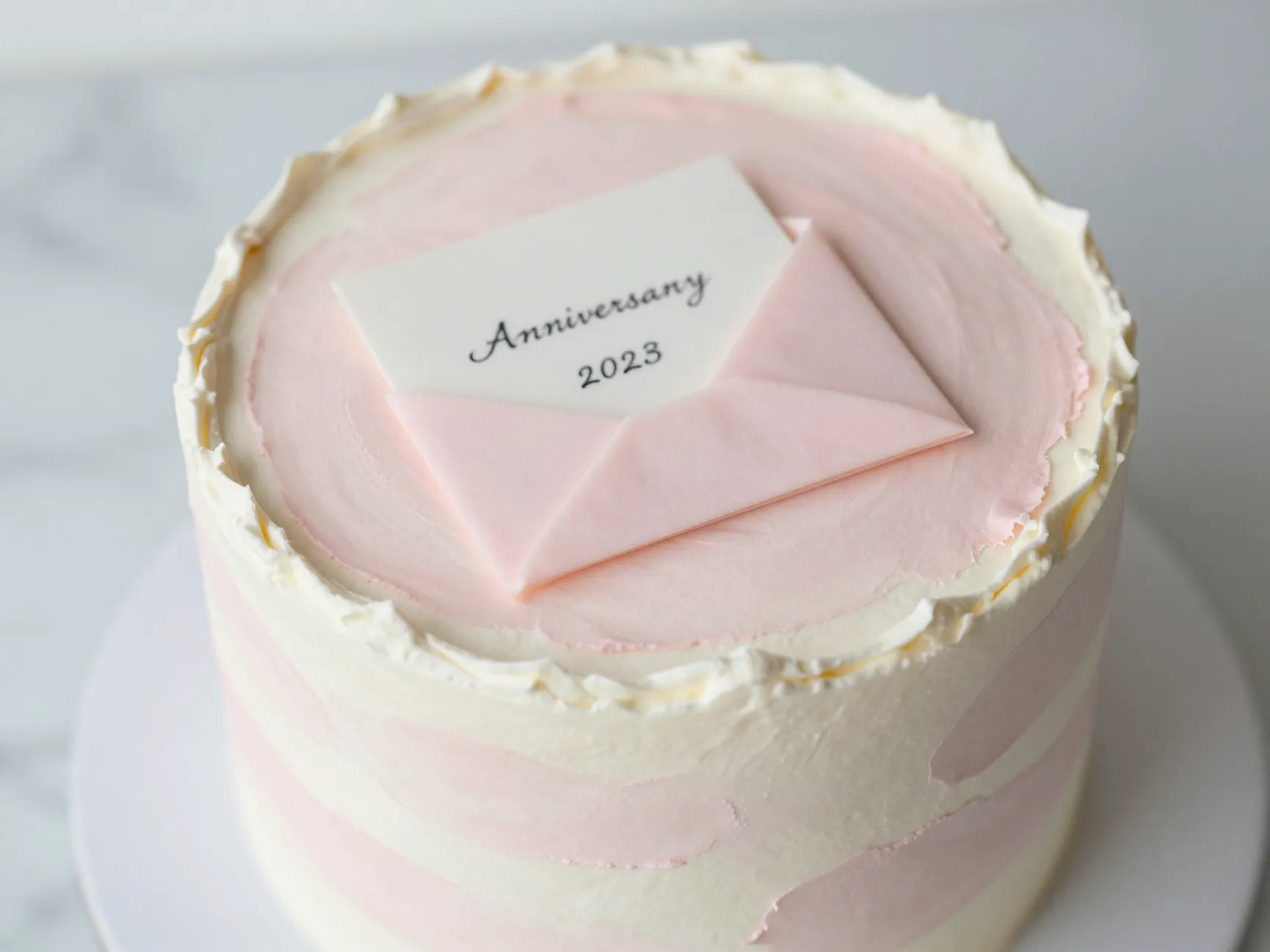 First anniversary paper cake with watercolor pastels and folded fondant