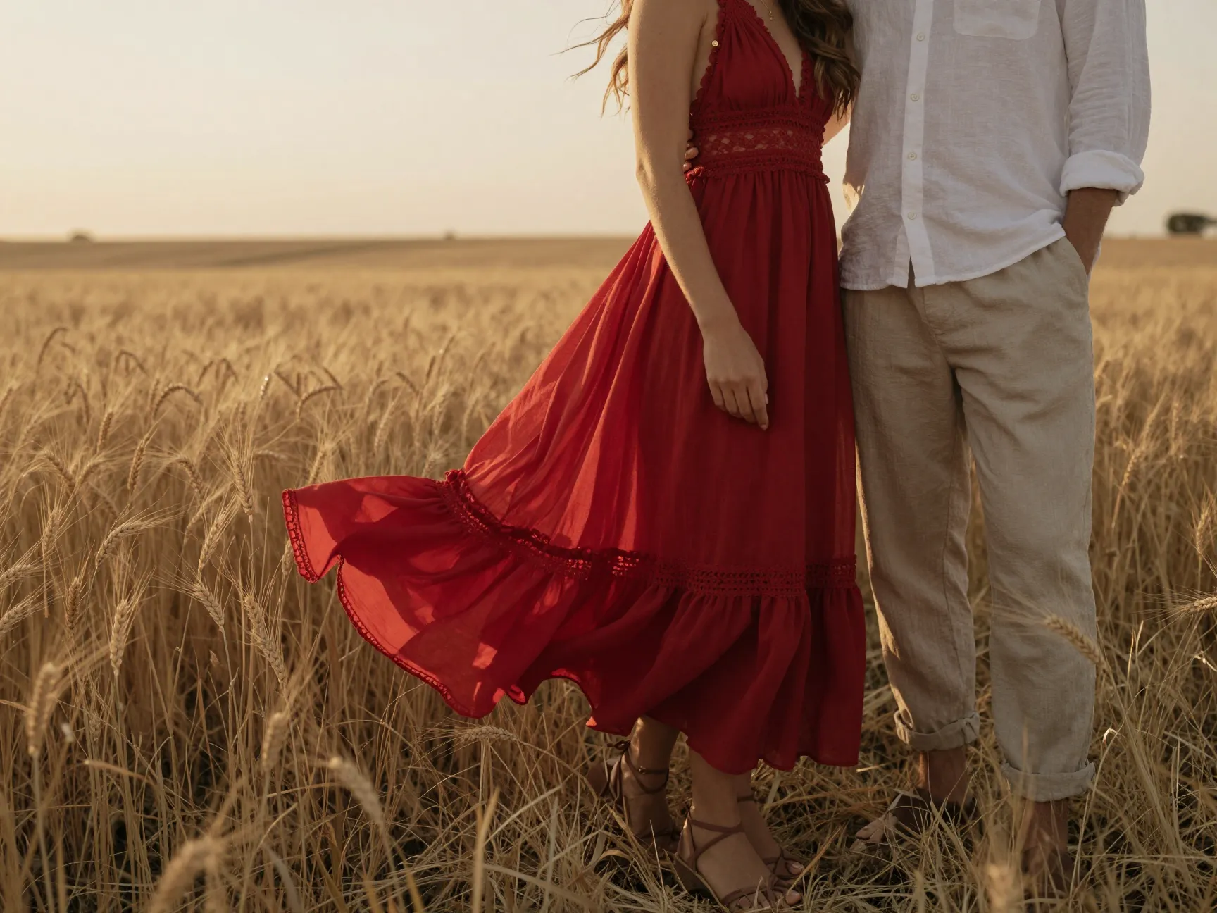 Flowy boho red maxi dress in wheat field at golden hour breeze