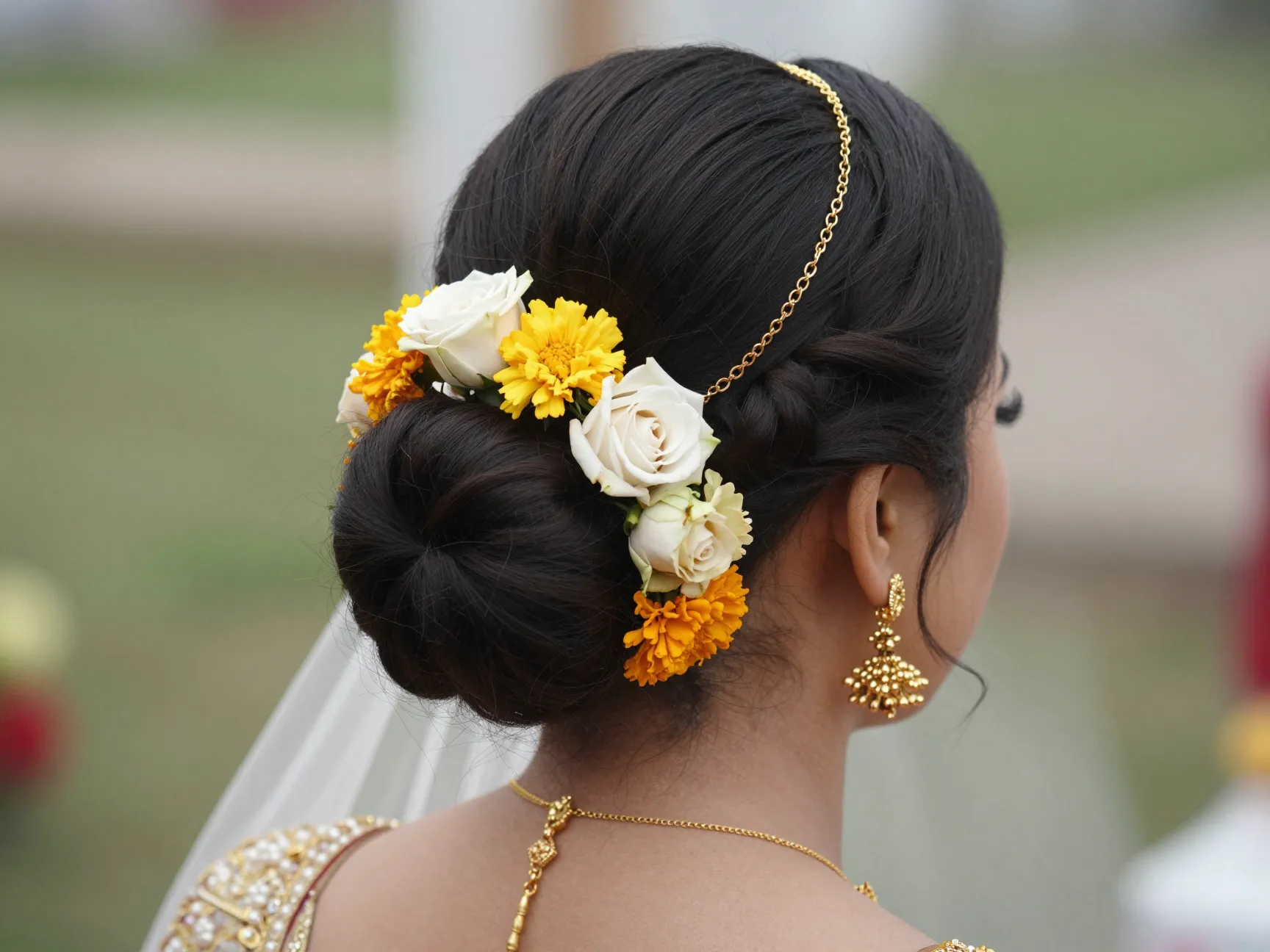 Low bun with floral adornments and a hair chain