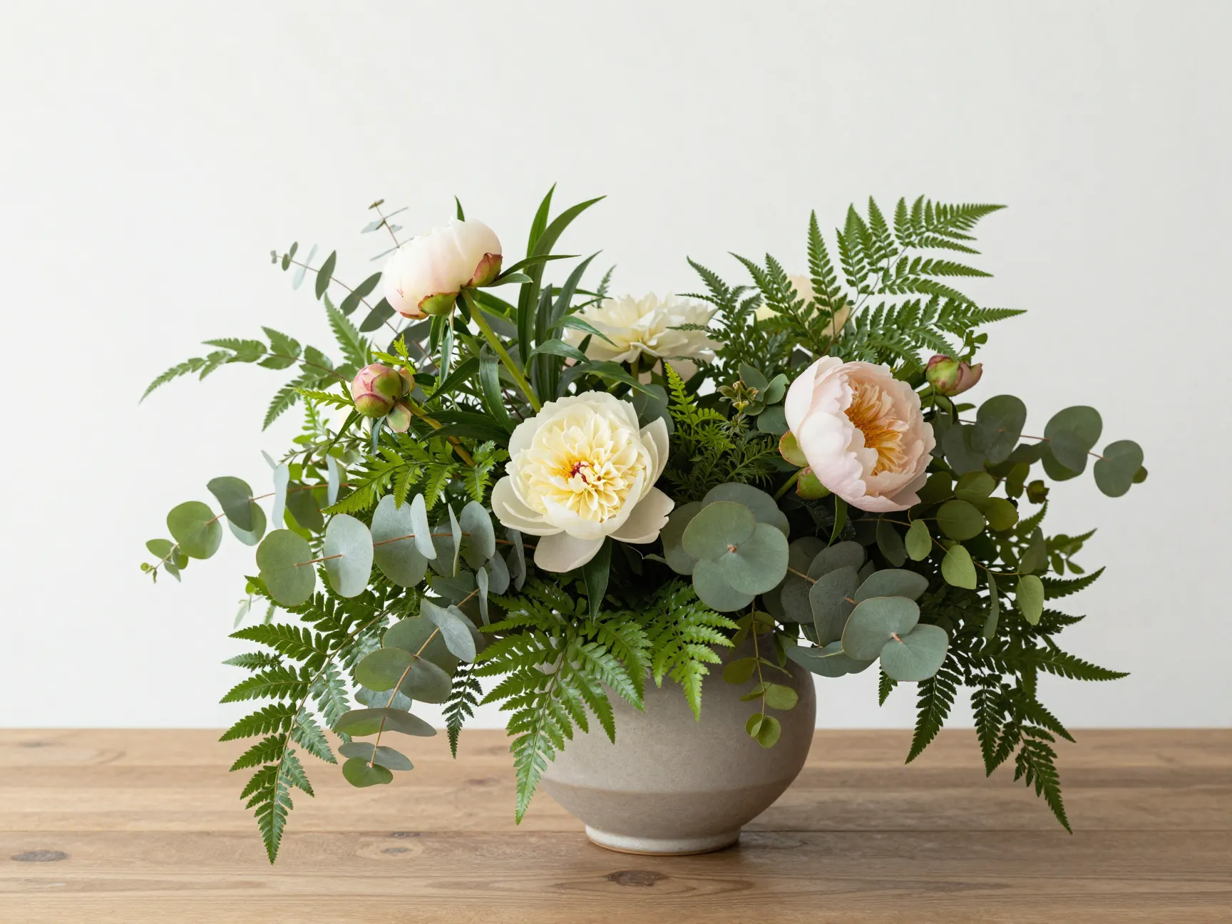 Elegant greenery heavy floral arrangement with seasonal blooms centerpiece