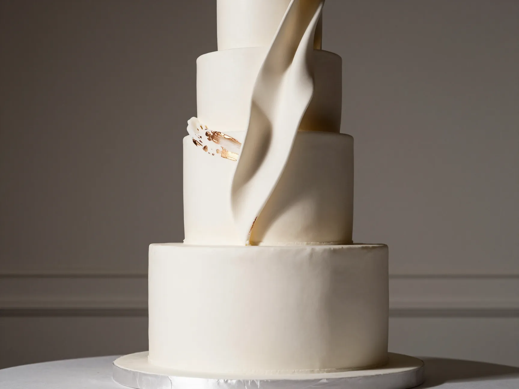 Oversized round single tier wedding cake with dramatic sugar sculpture and metallic accents