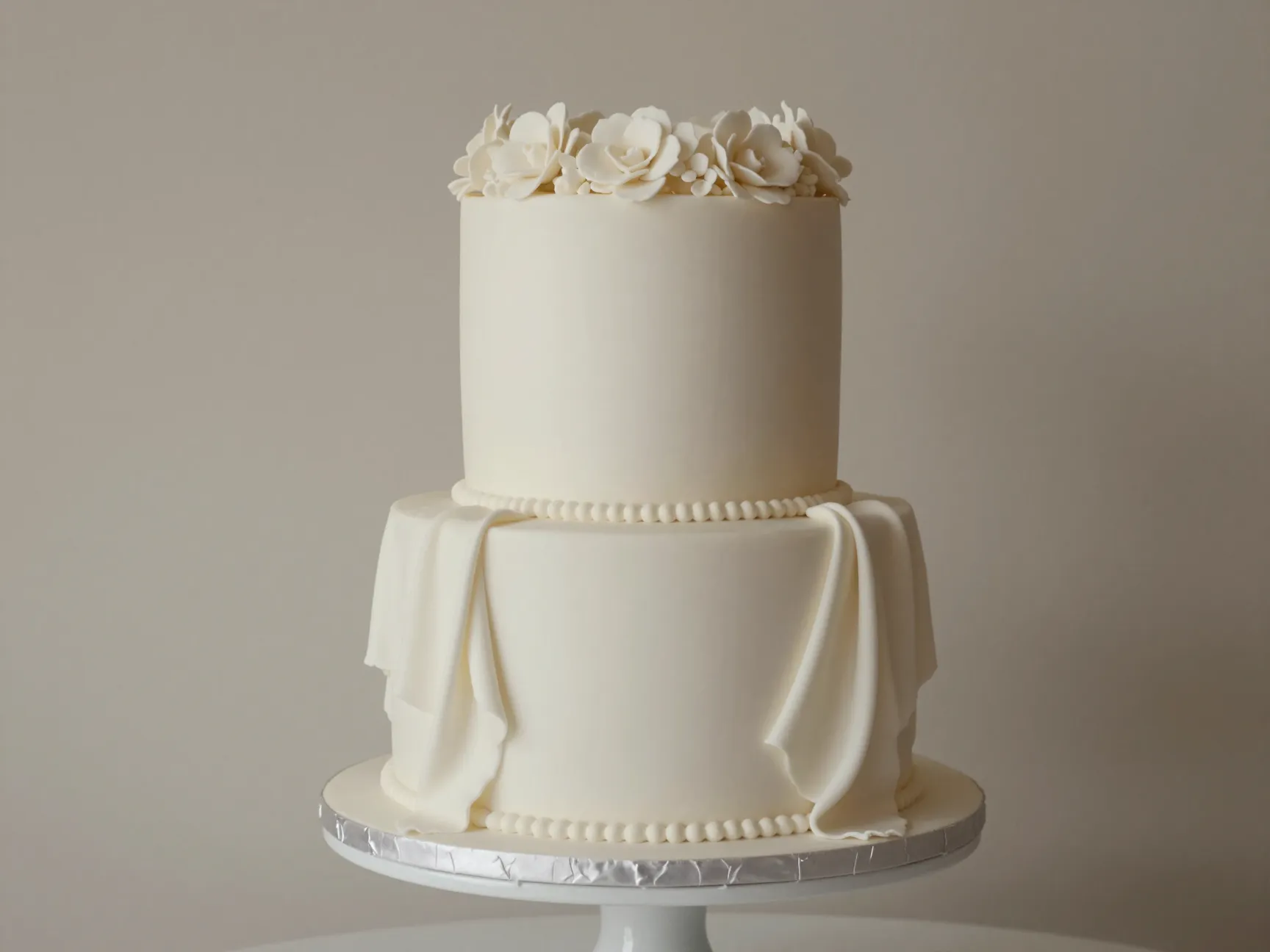 Elegant oval single tier wedding cake with draped fondant and floral crown