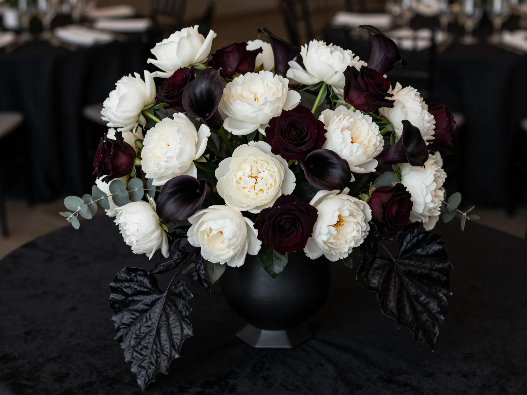Dramatic black and white floral arrangement in architectural black vase