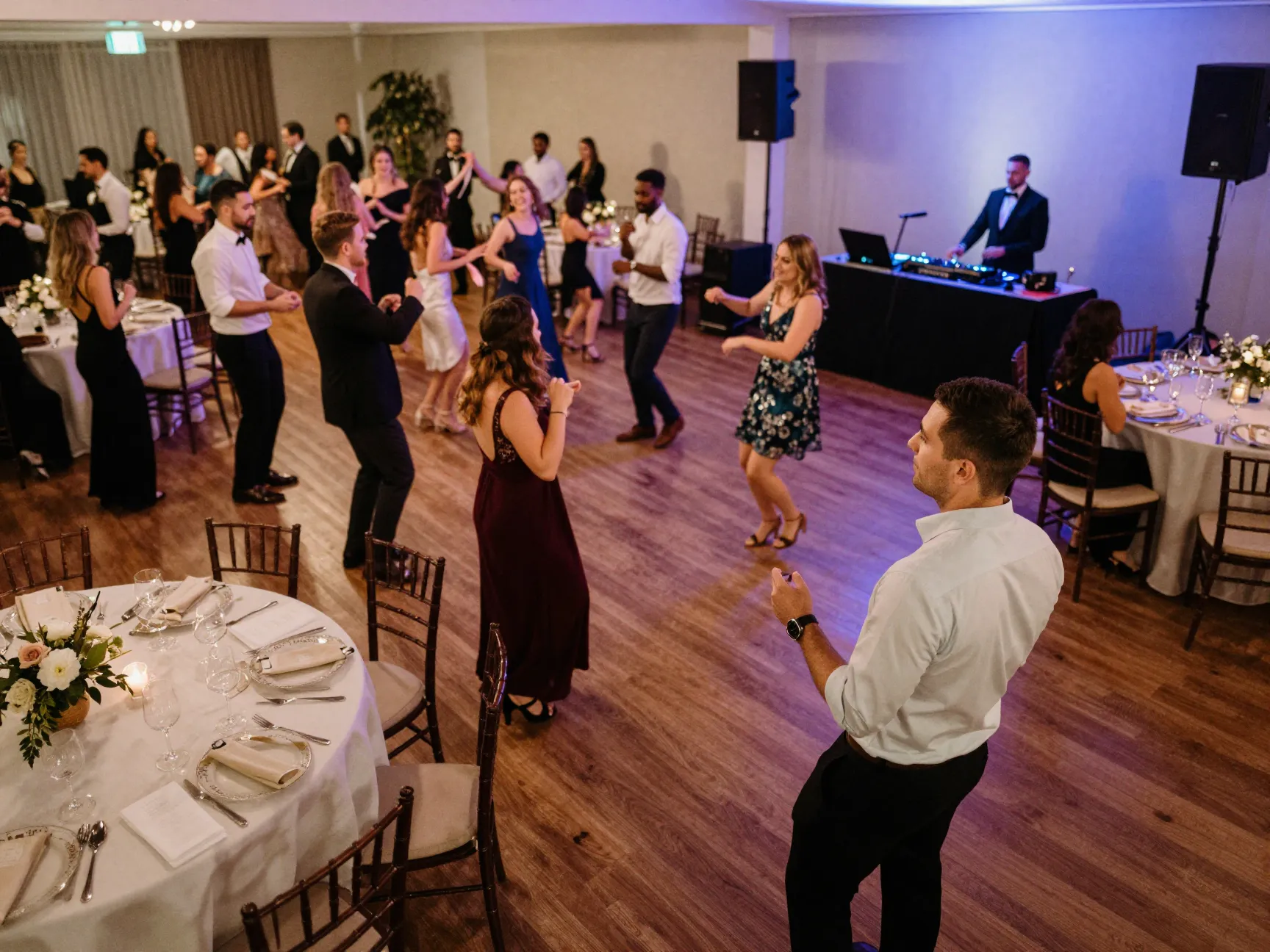 Wedding planner overseeing reception flow and lively dance floor energy