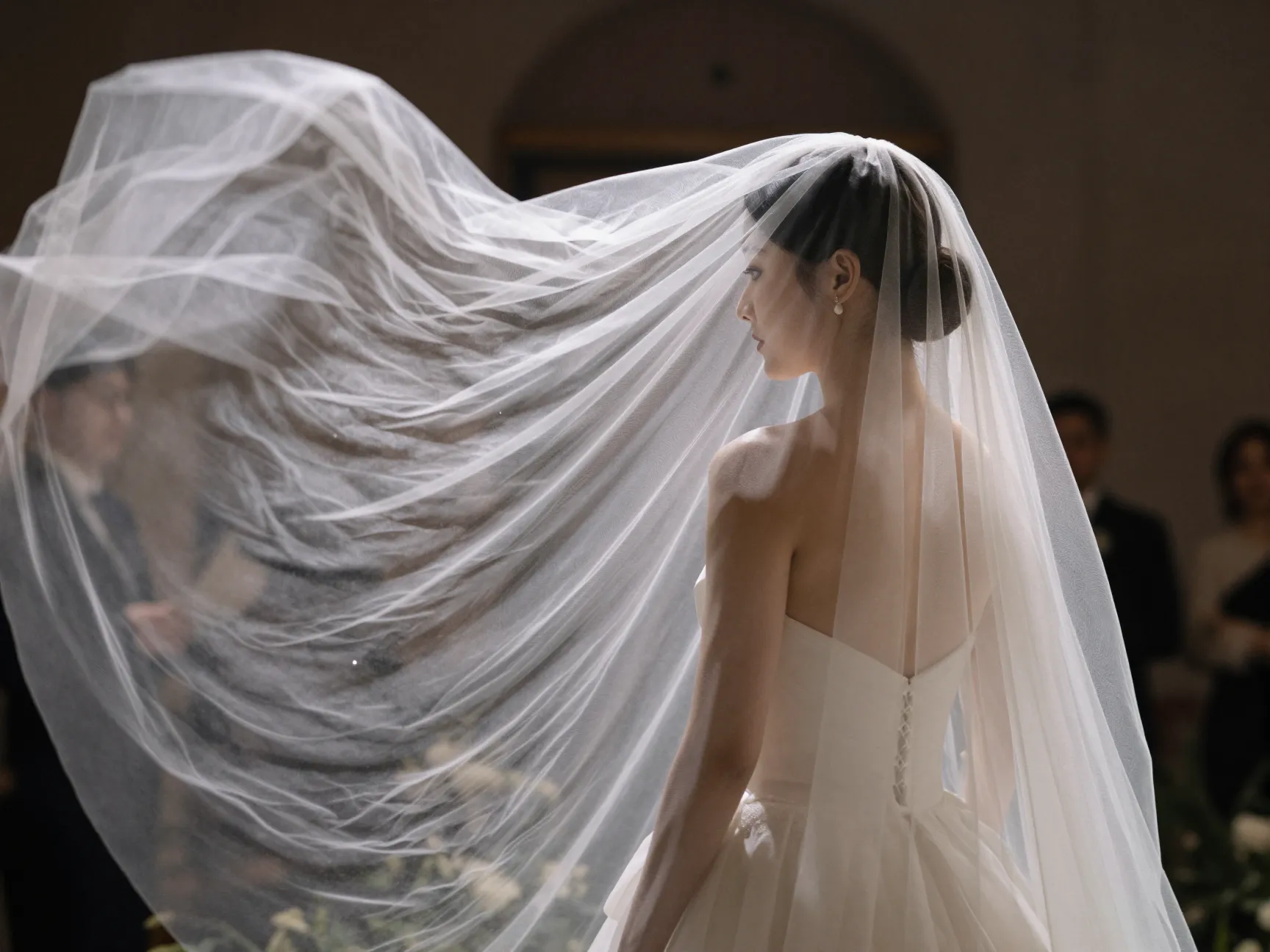 Traditional ceremony bride low bun with cathedral veil dramatic