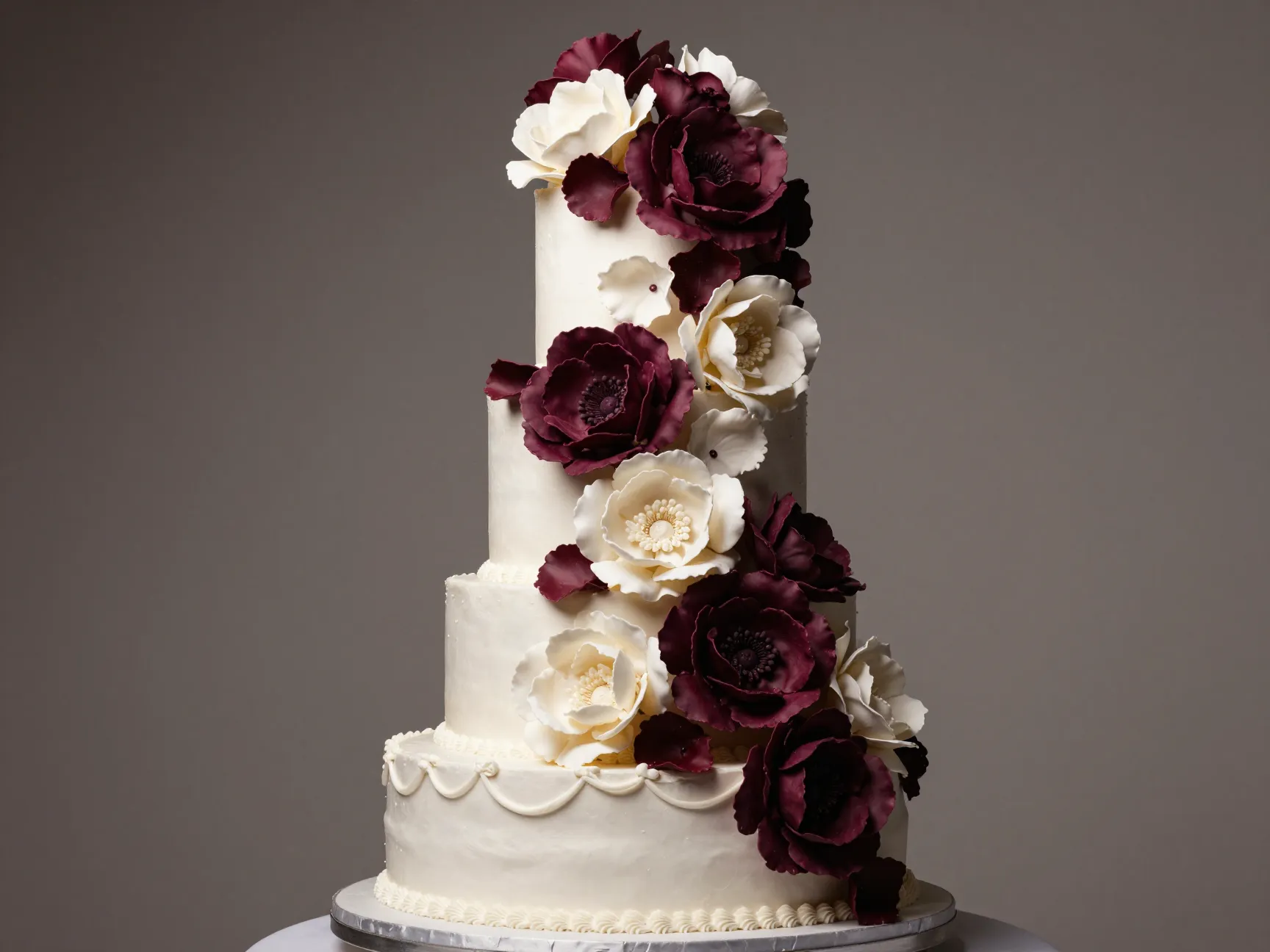 Statement floral cake with oversized blooms in deep plum and ivory
