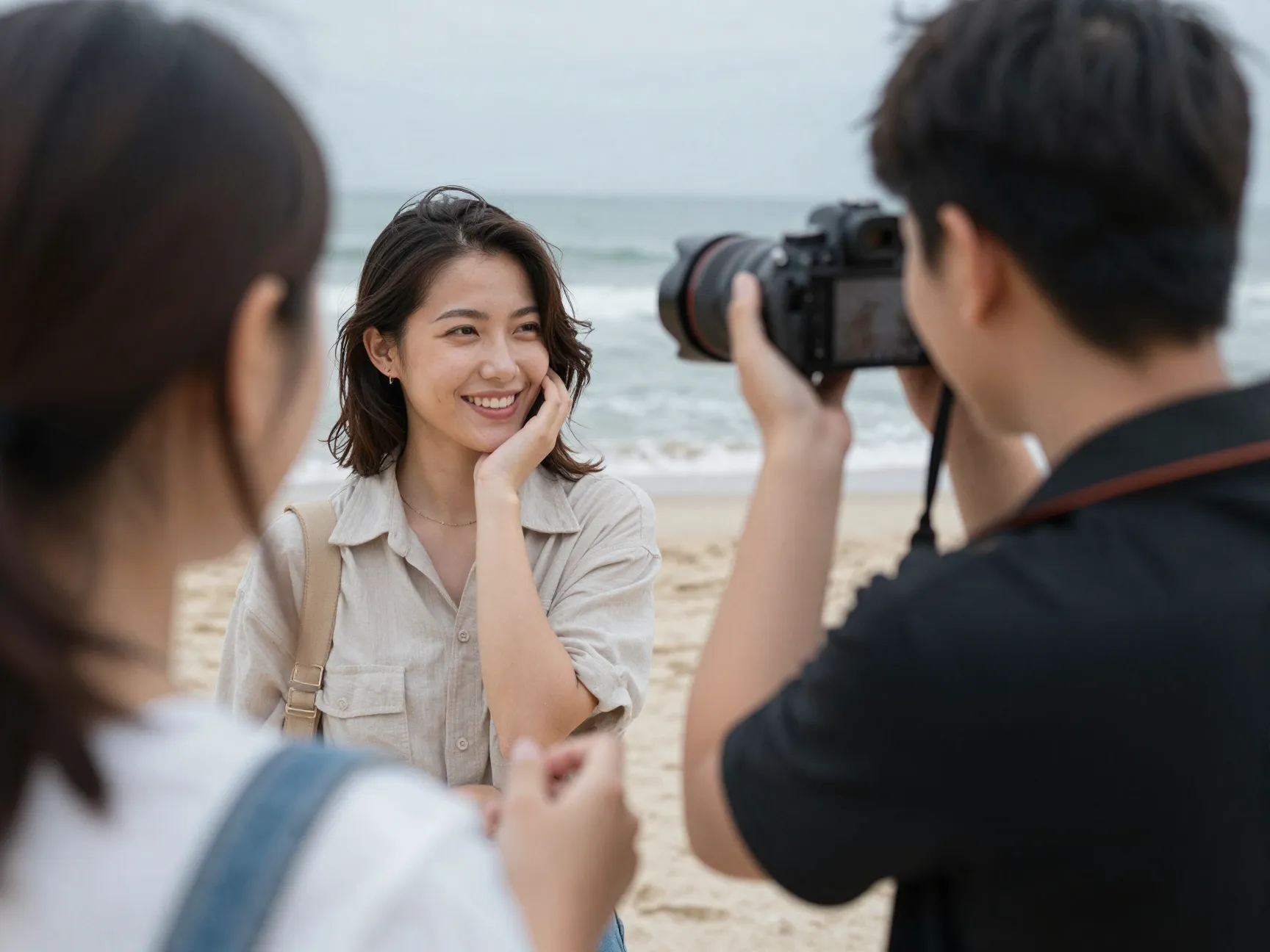 Woman photographing her partner with professional camera on beach