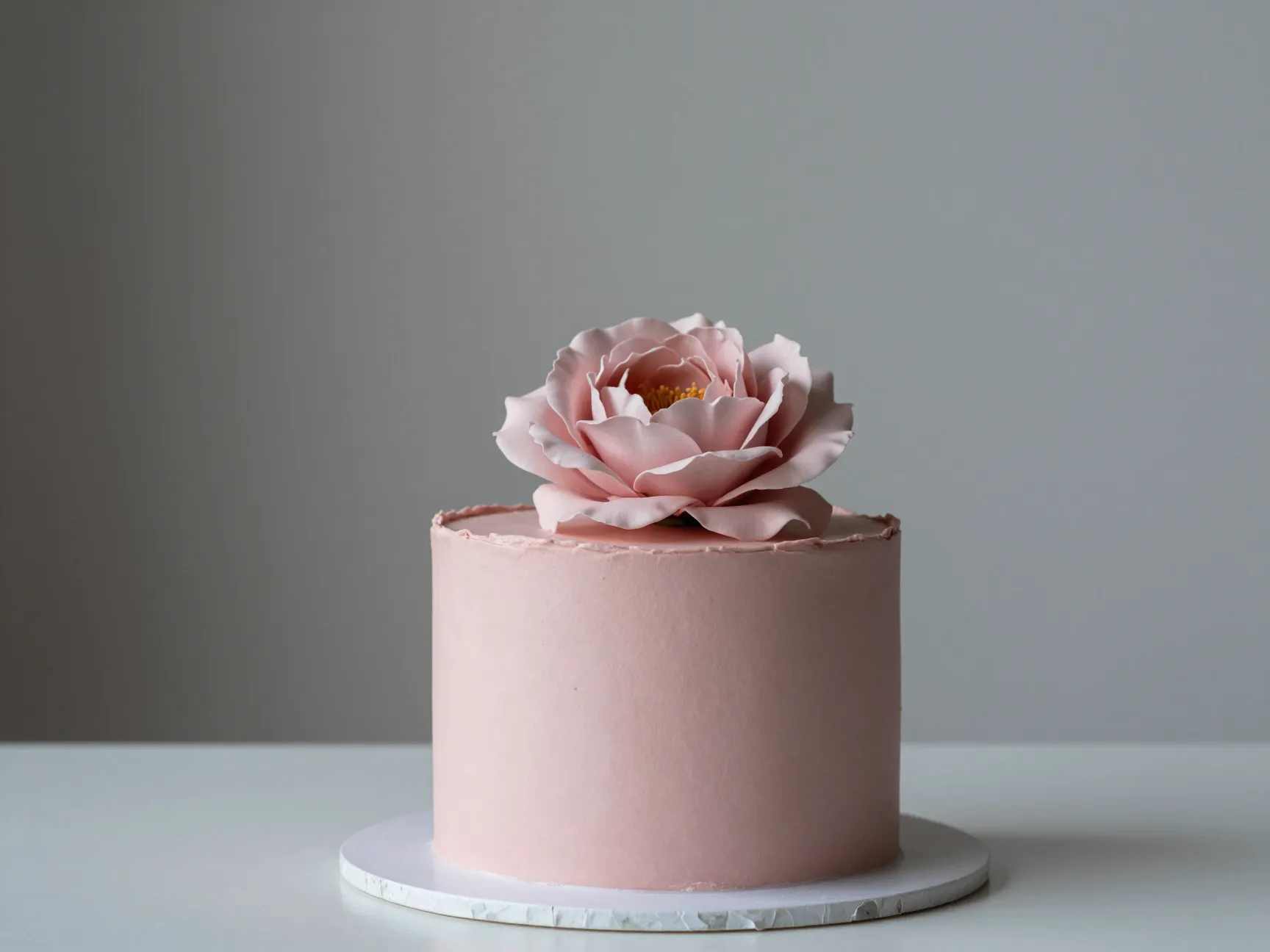 Minimalist romantic single tier cake with one statement bloom