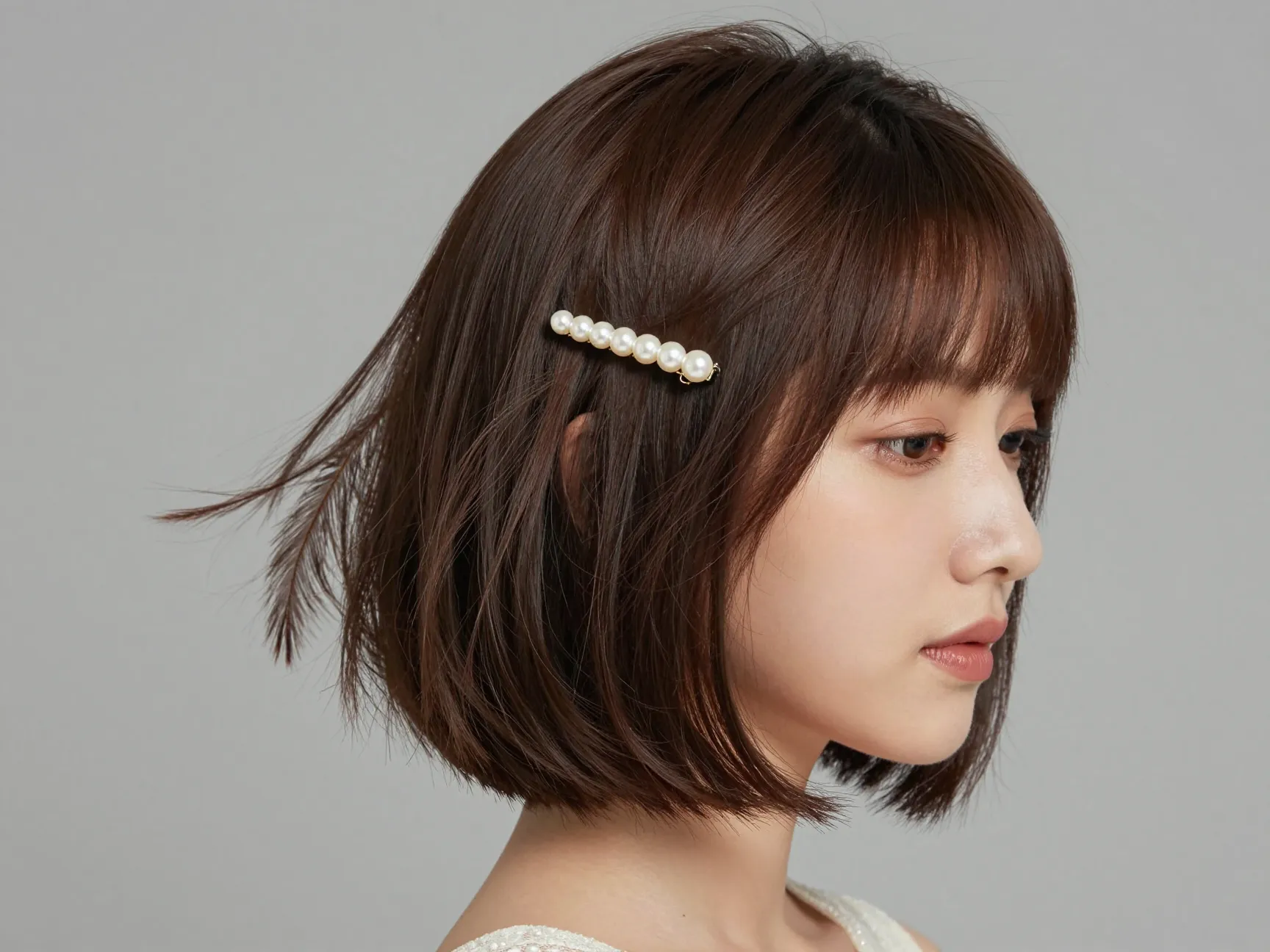 A guest with a chic feathered bob and a pearl clip at a cocktail wedding