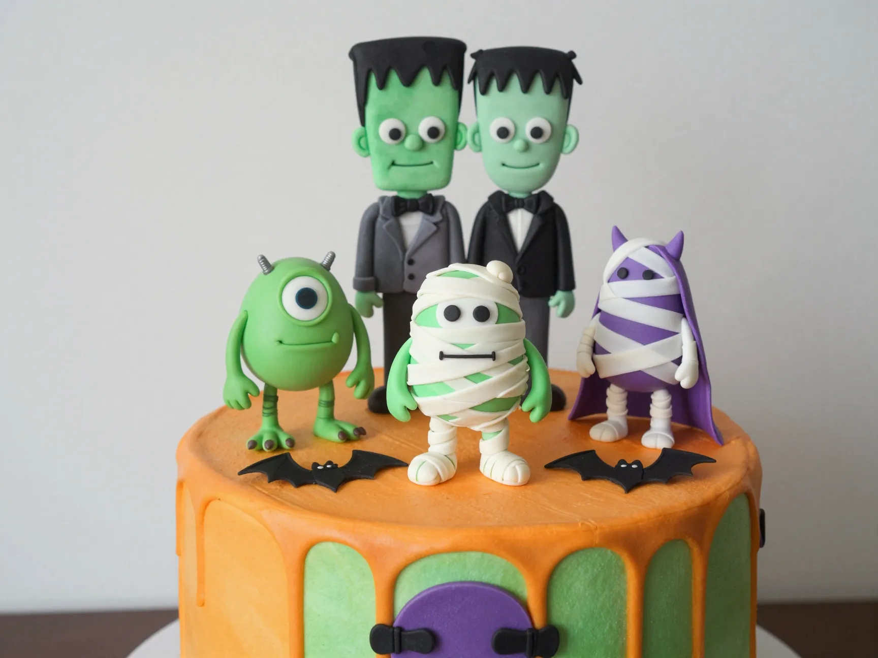 Playful whimsical monster cake with fondant frankenstein and mummy toppers