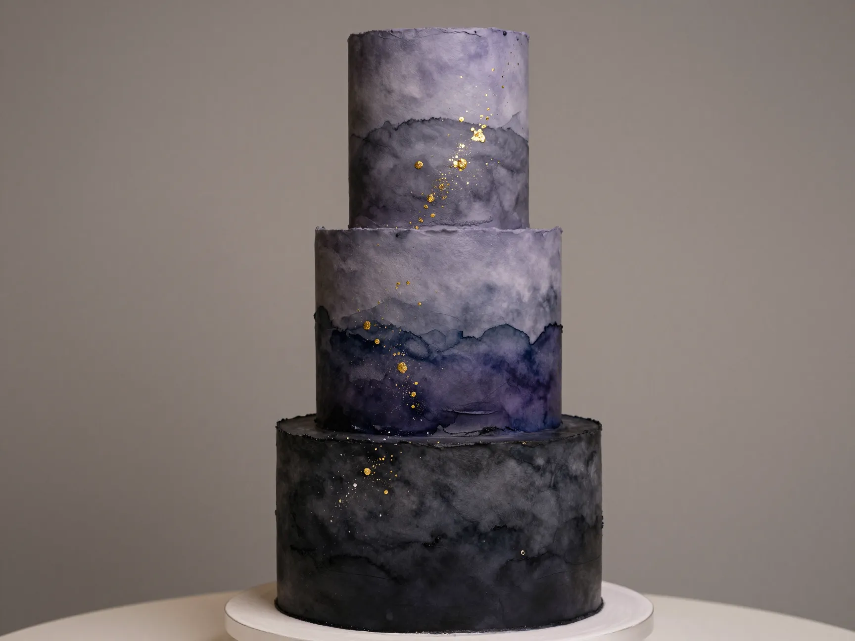 Dark ombre watercolor wedding cake with edible gold splatter