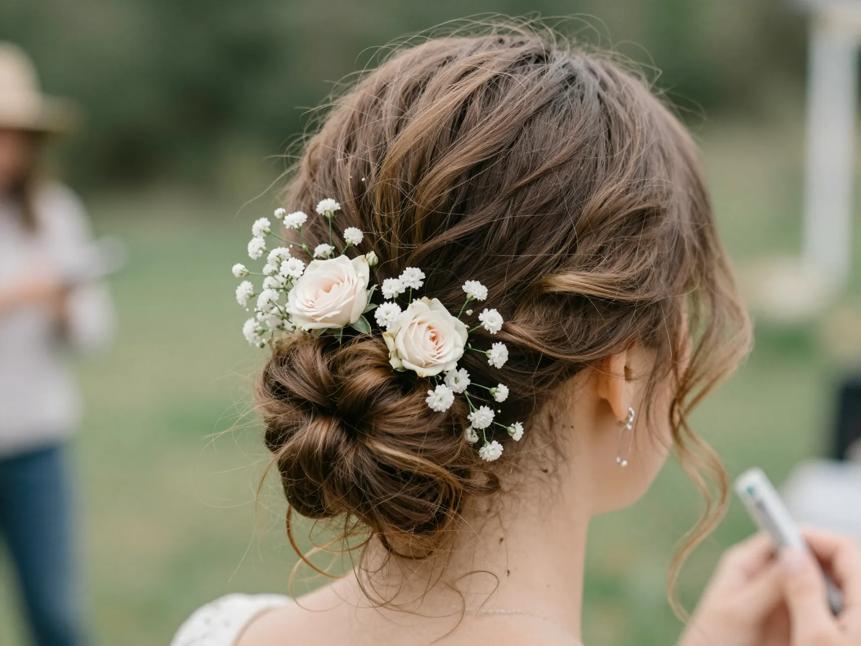 Soft updo with intentional loose tendrils and fresh floral accents