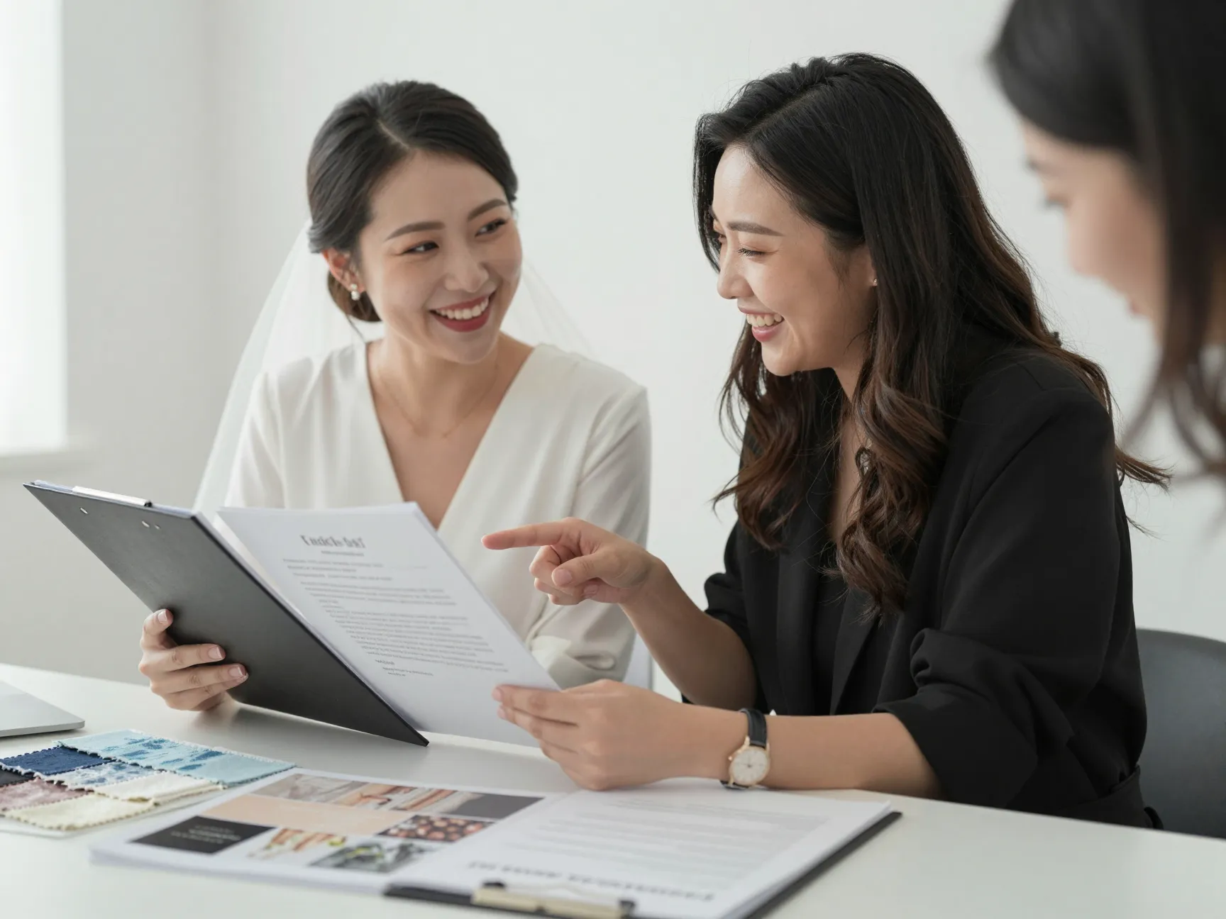 Bride and wedding planner reviewing vendor contracts and laughing together