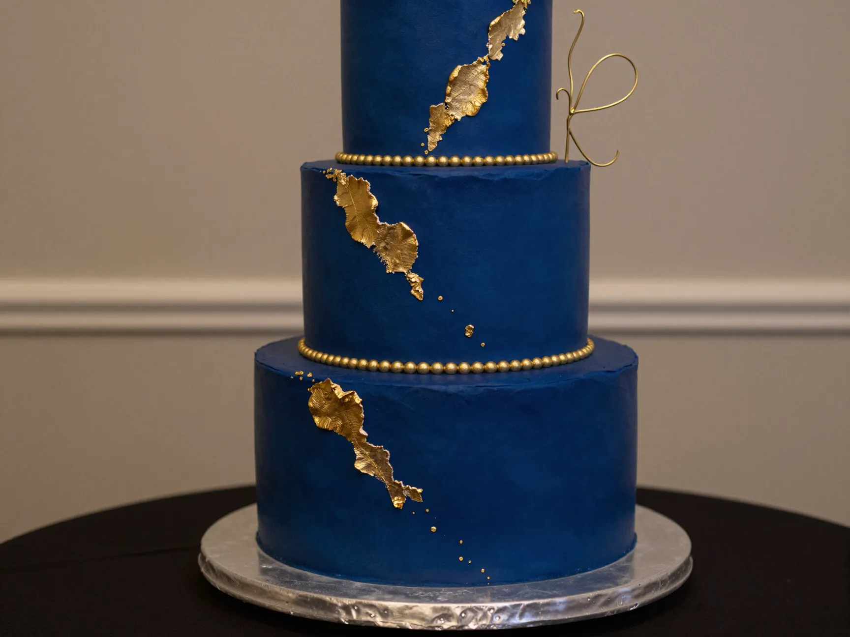 Bold jewel tone wedding cake with gold accents on elegant table