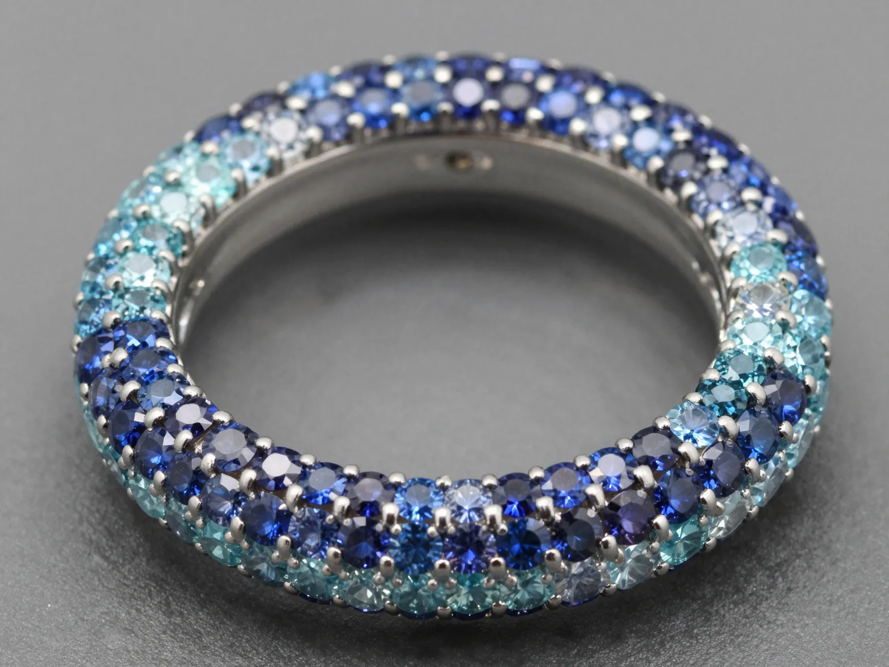 Gemstone encrusted wedding band with ombre sapphire to aquamarine gradient