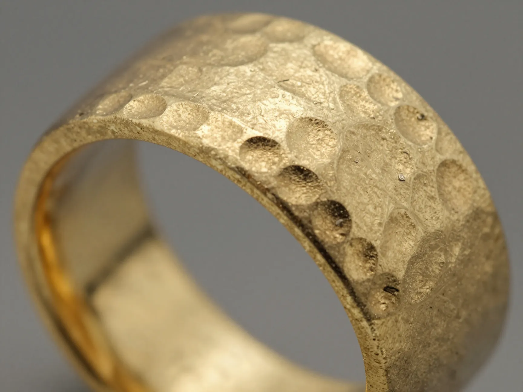 Textured wedding band with hammered gold finish and artisanal details