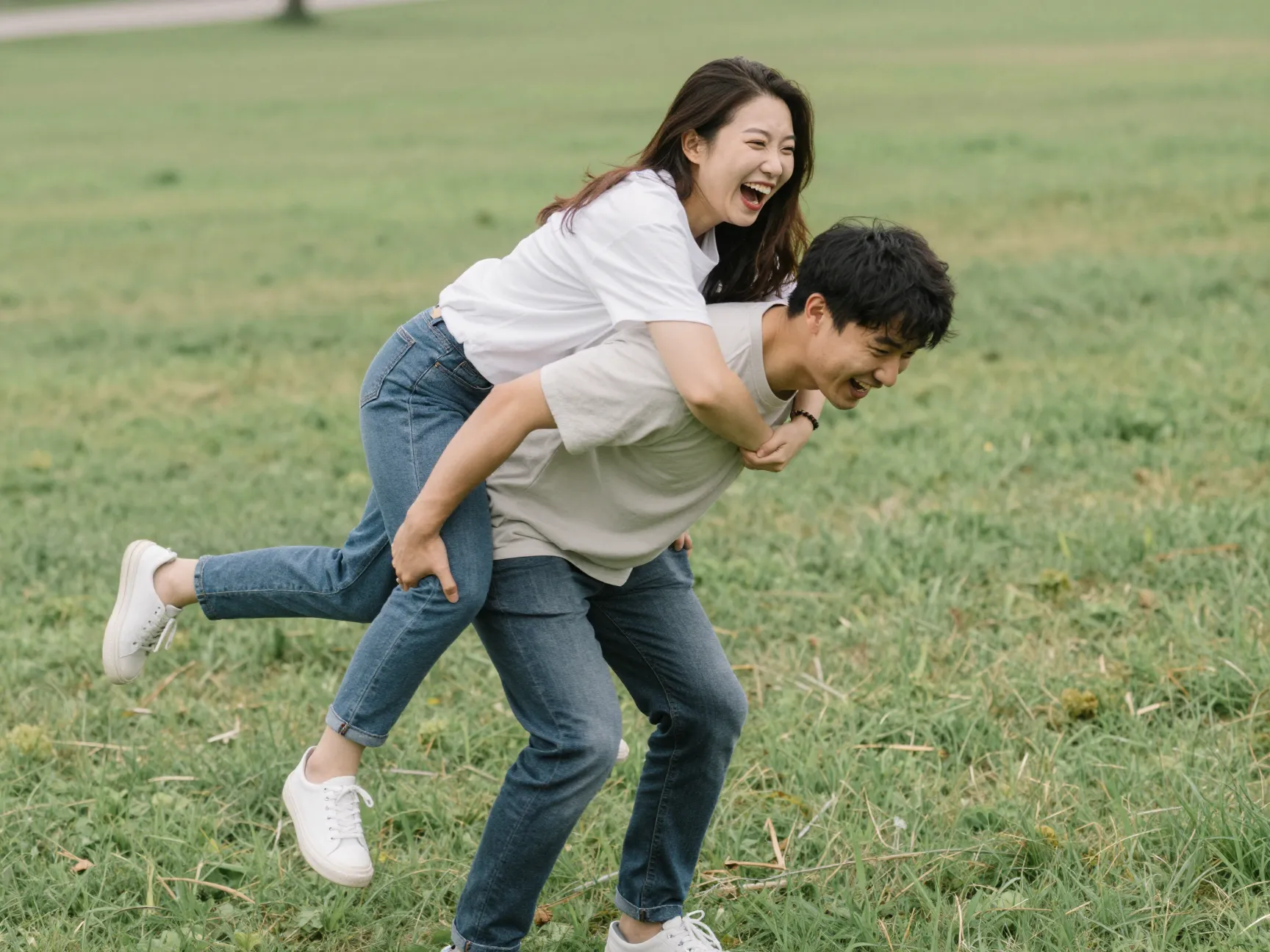 Piggyback ride playful couple laughter wobbling outdoor grass engagement