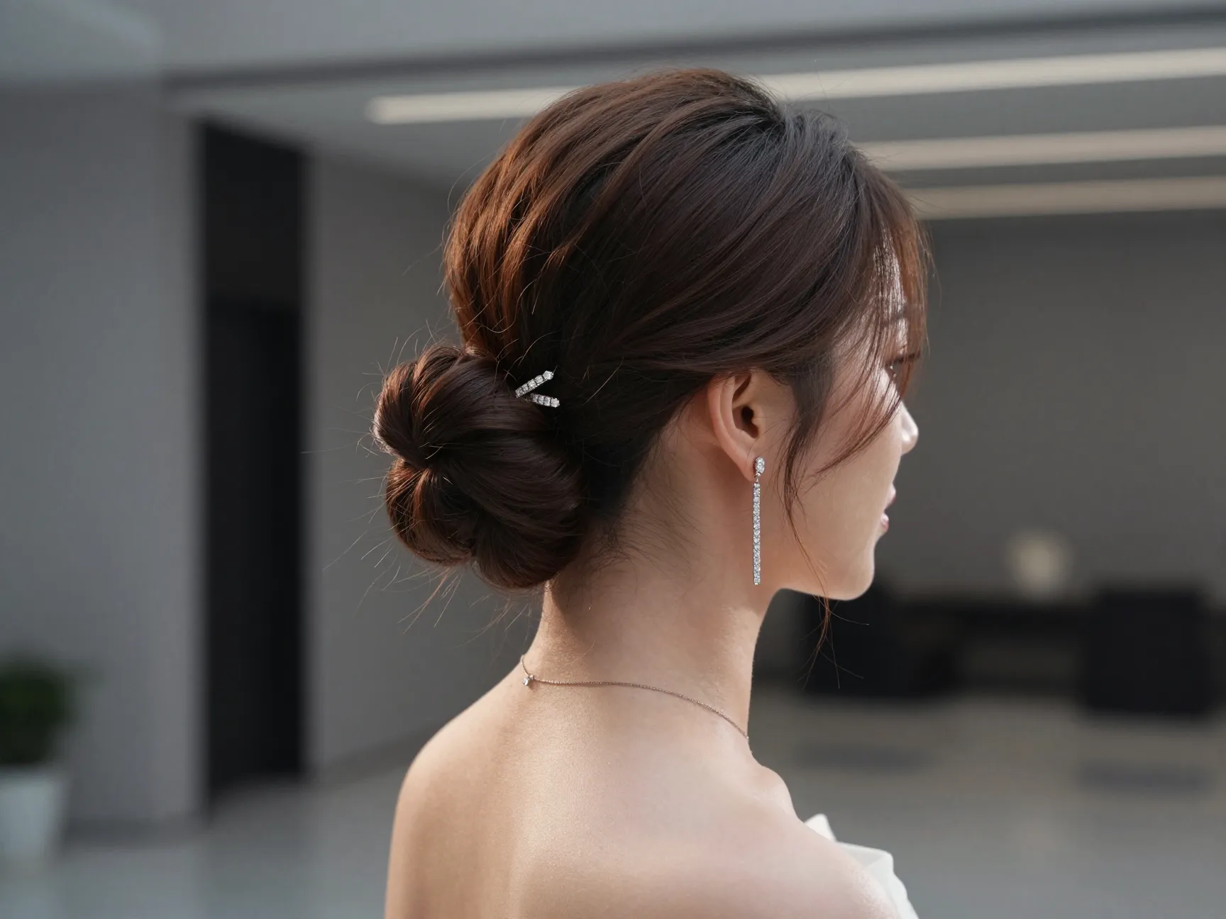 Bride with high swept twist updo and drop earrings at modern venue