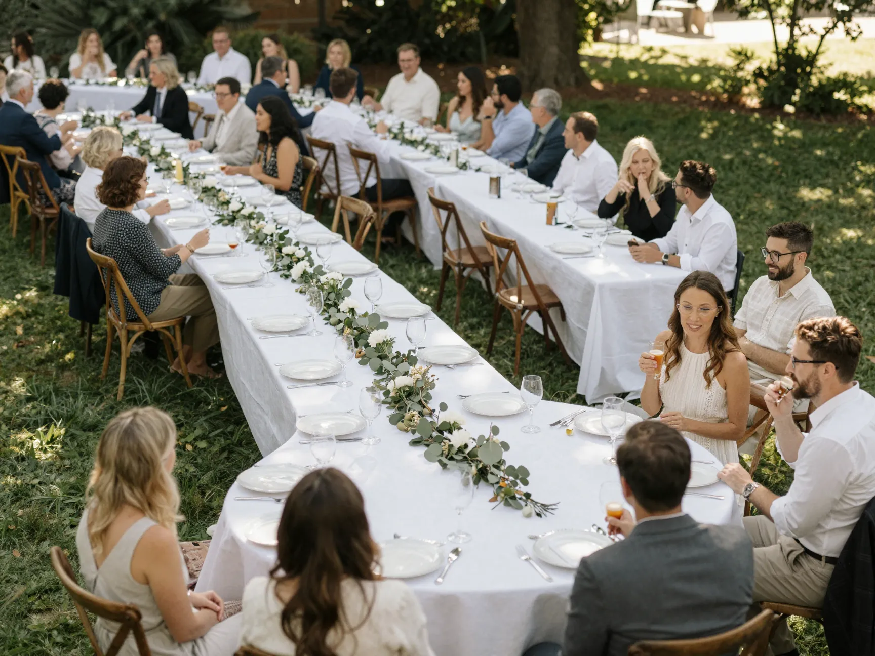 Serpentine table layout flowing through outdoor wedding reception space