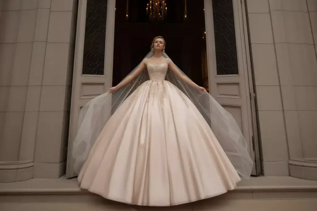 A bride in a voluminous white gown and veil stands in front of tall ornate doors.