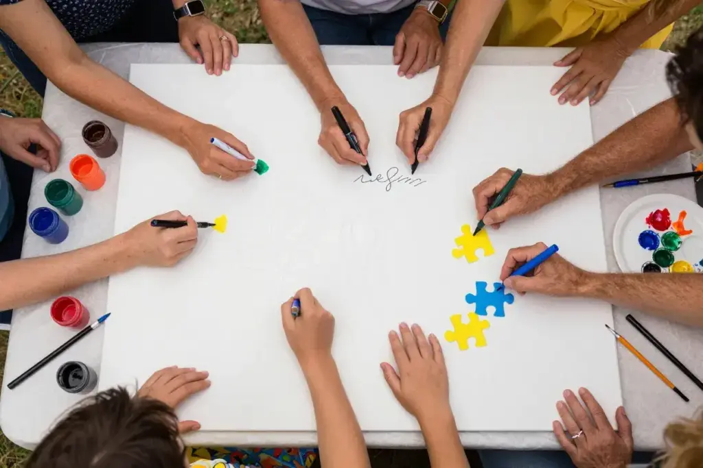 Overhead shot of hands painting and signing collaborative wedding canvas