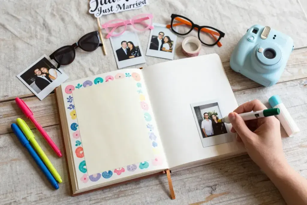 Flatlay of instant camera photos and scrapbook guest memory album