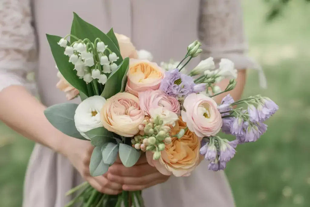 Pastel bouquet lily of the valley with peach roses and lavender