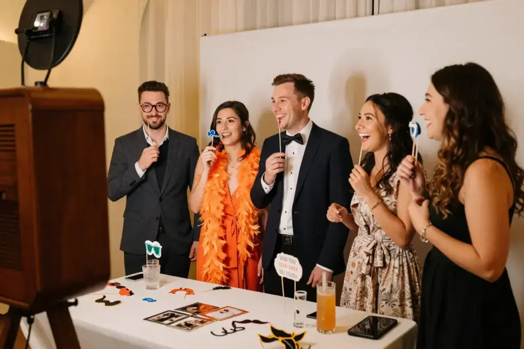 Guests from different groups mingling over photo booth props table