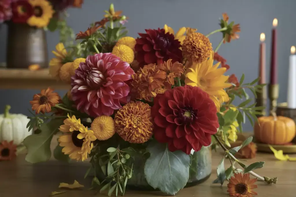 Seasonal floral arrangement burgundy dahlias orange marigolds closeup