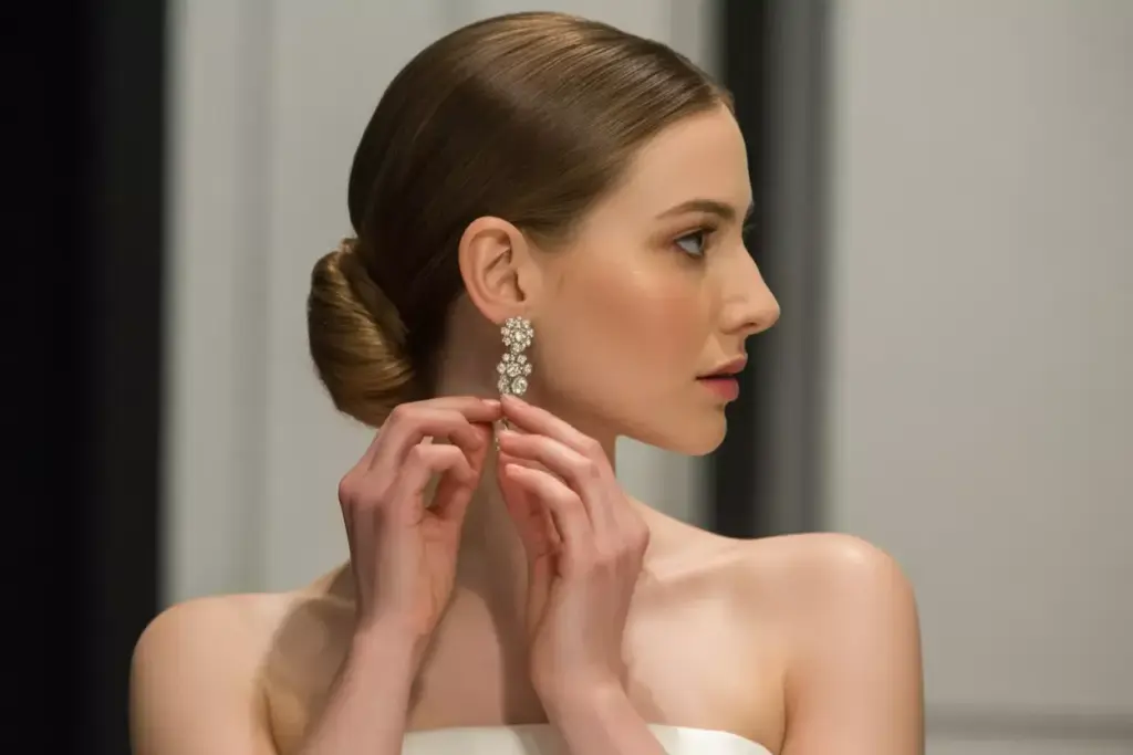 Sleek french twist showcasing statement earrings and strapless neckline