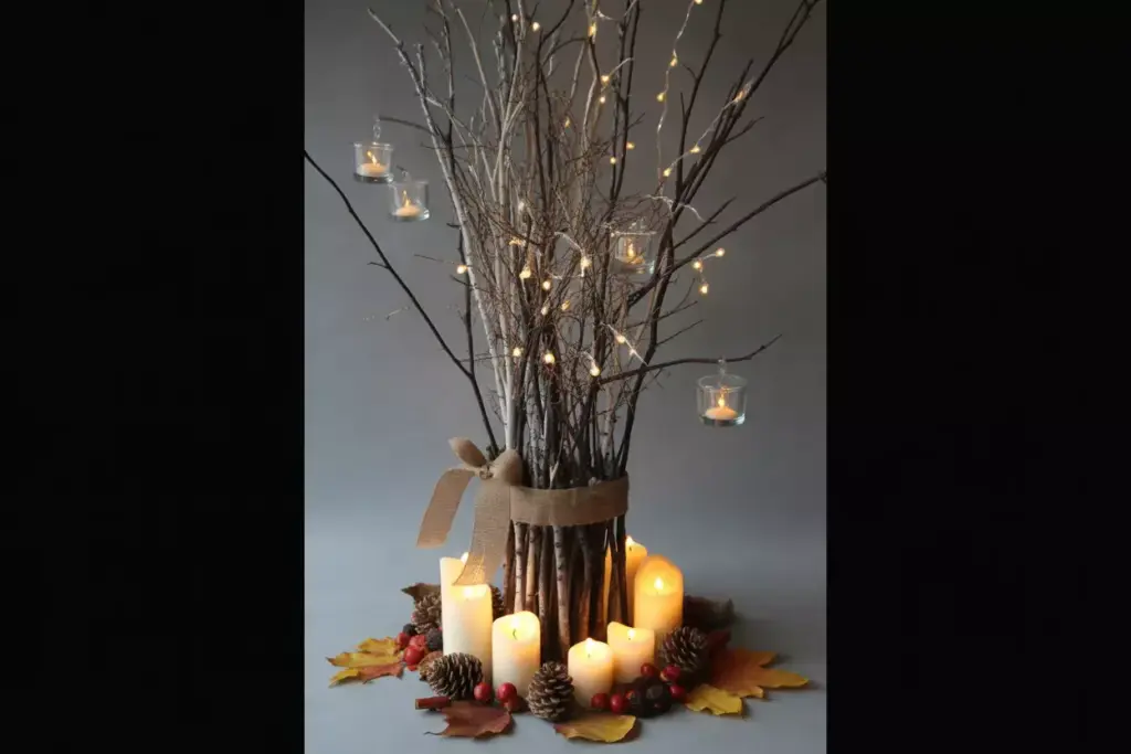 Tall candlelit branch arrangement with fairy lights and hanging votives