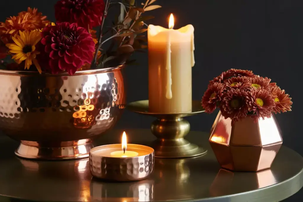 Copper bowl and bronze candlestick with autumn flowers and candlelight