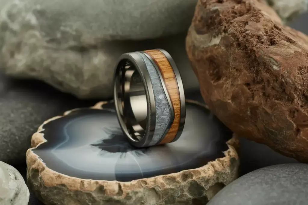 Tungsten band with wood inlay resting on a geode slice