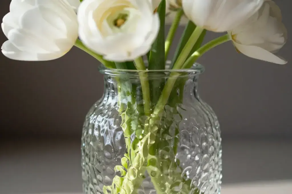 Ribbed textured glass vase with simple white tulips