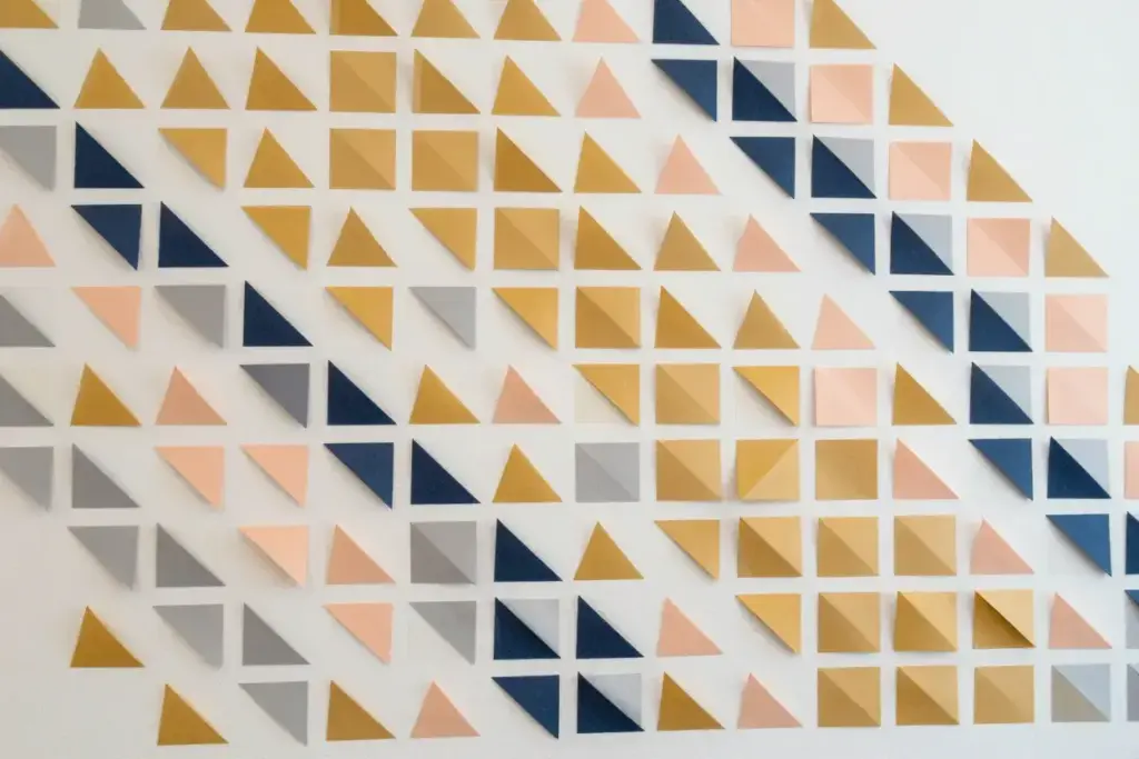 Modern geometric wall pattern made from colored paper triangles