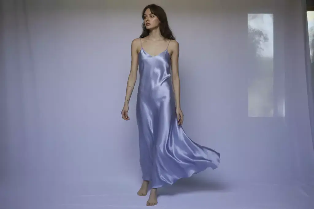 Periwinkle silk slip dress draping natural light